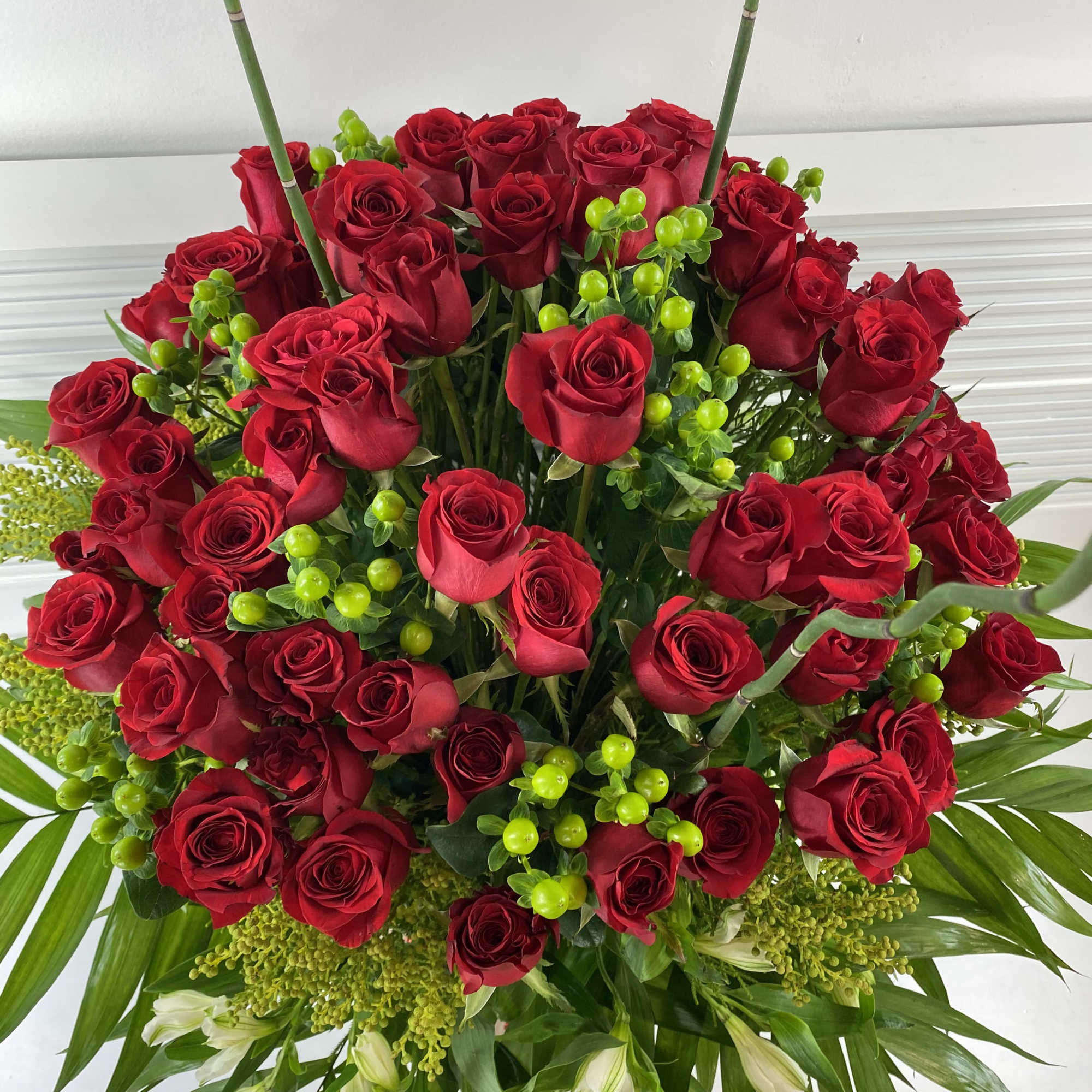 70 long stem red roses and greenery in a rattan big basket