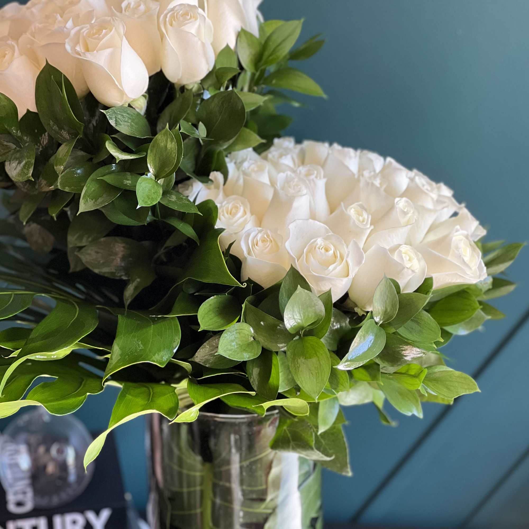 50 white roses design with greenery in a vase 