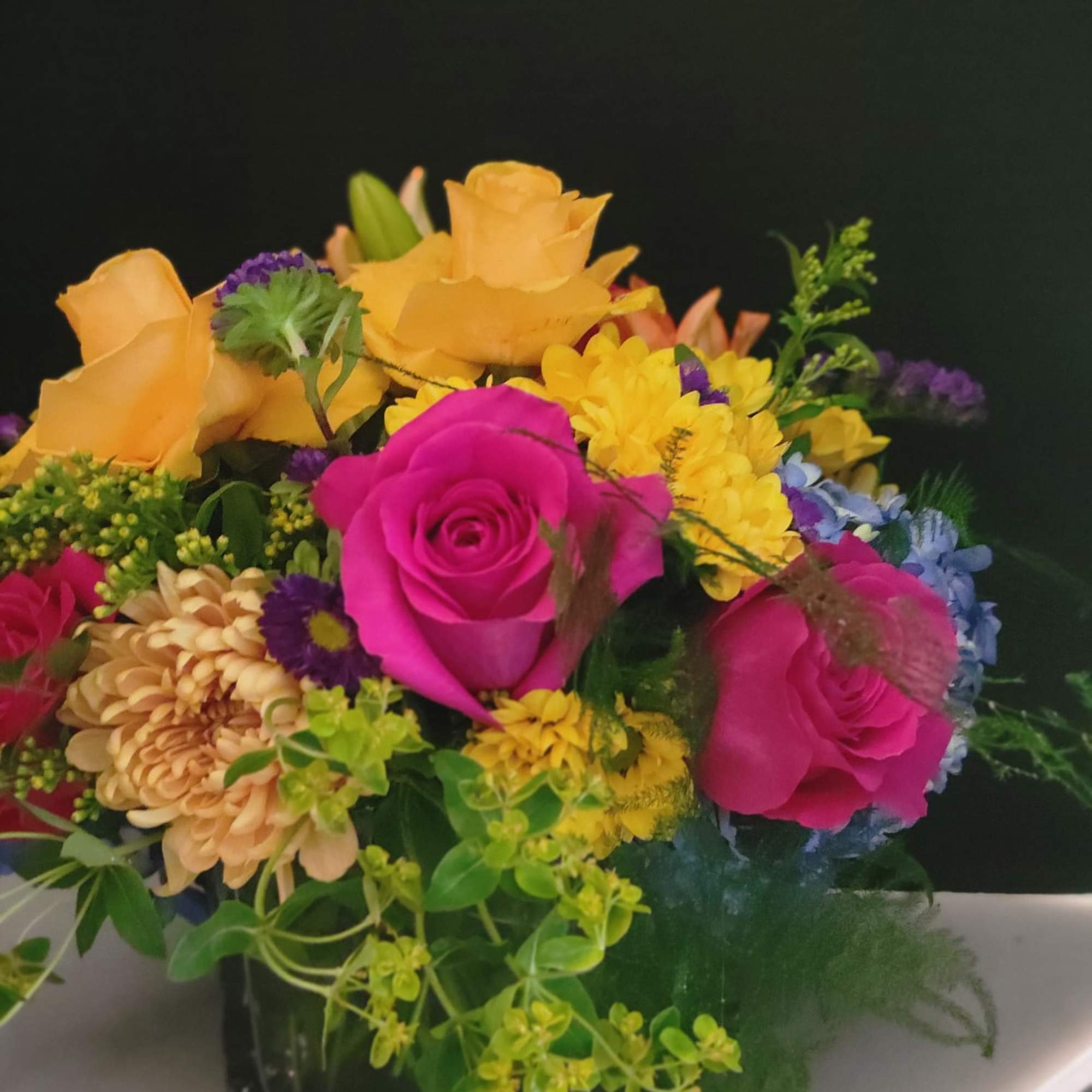 A vibrant color arrangement with hydrangeas, roses, stock, mums, and fillers