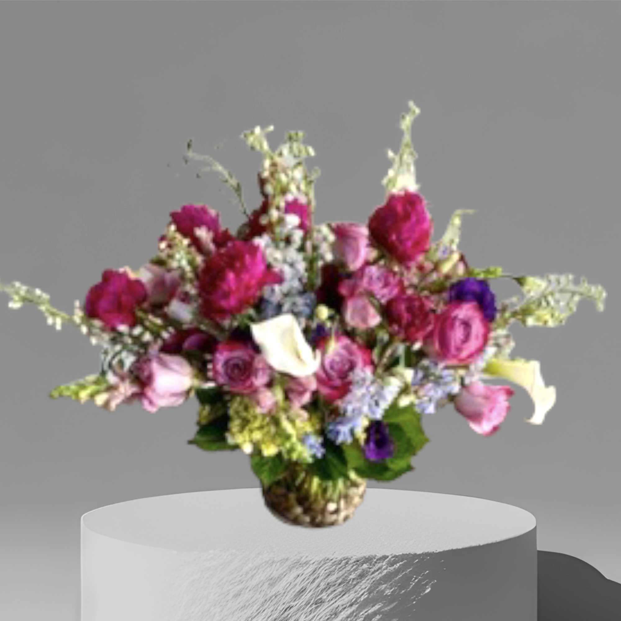 Pinks and purples surrounded by seasonal foliage and flowers in a glass