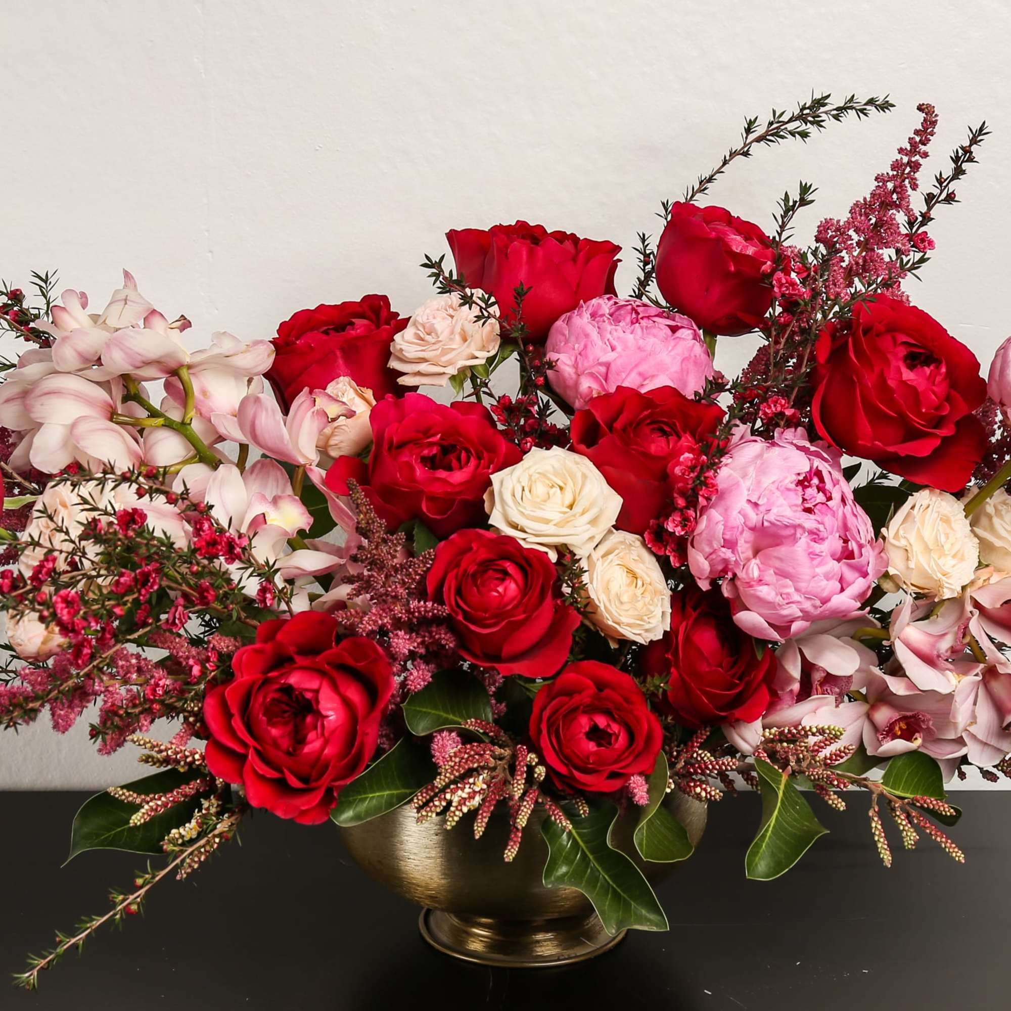 Composed of roses, spray roses, orchids, peonies, astilbe, variety of green.