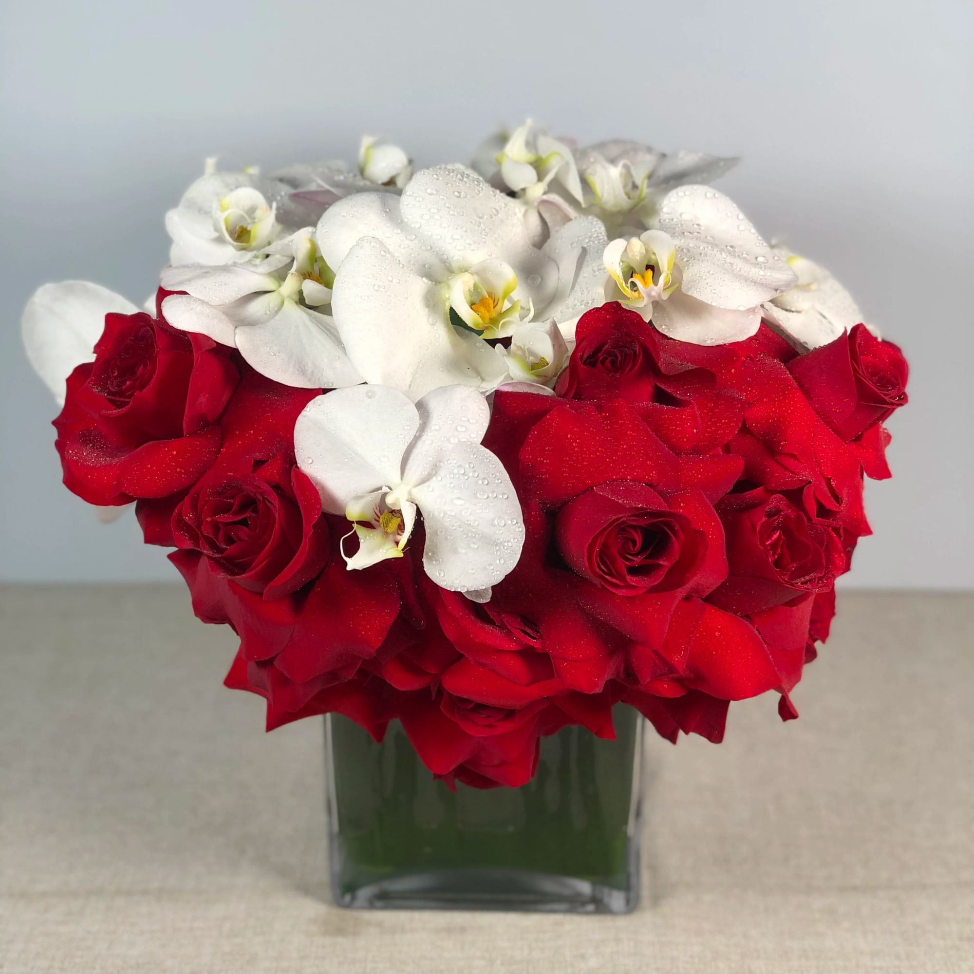 An ultra chic and modern but romantic arrangement with deep red roses