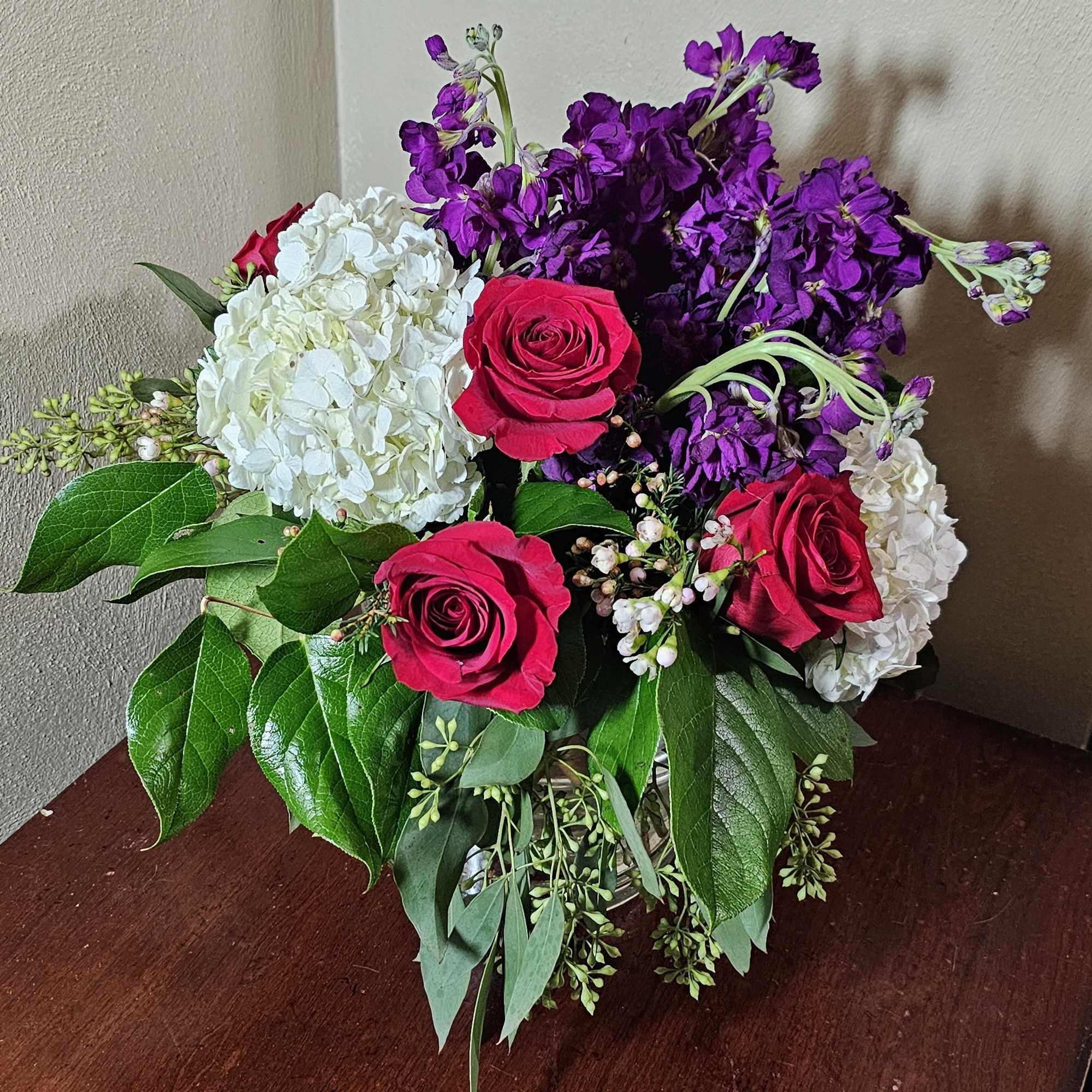 All around arrangement with royal colors of love in a cylindrical glass