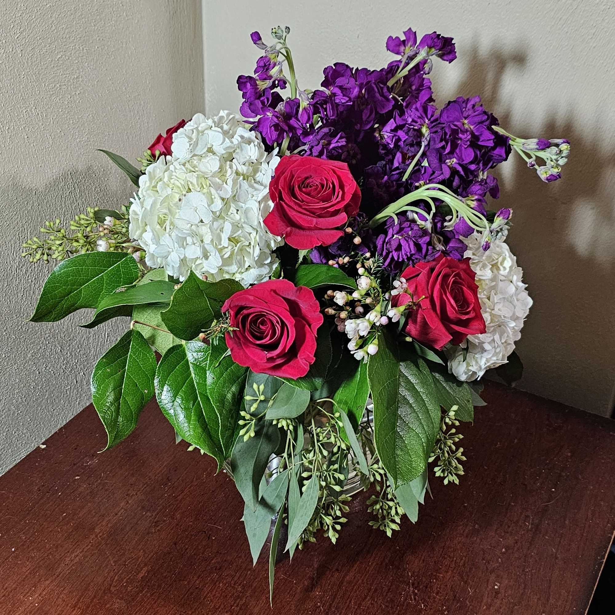 All around arrangement with royal colors of love in a cylindrical glass