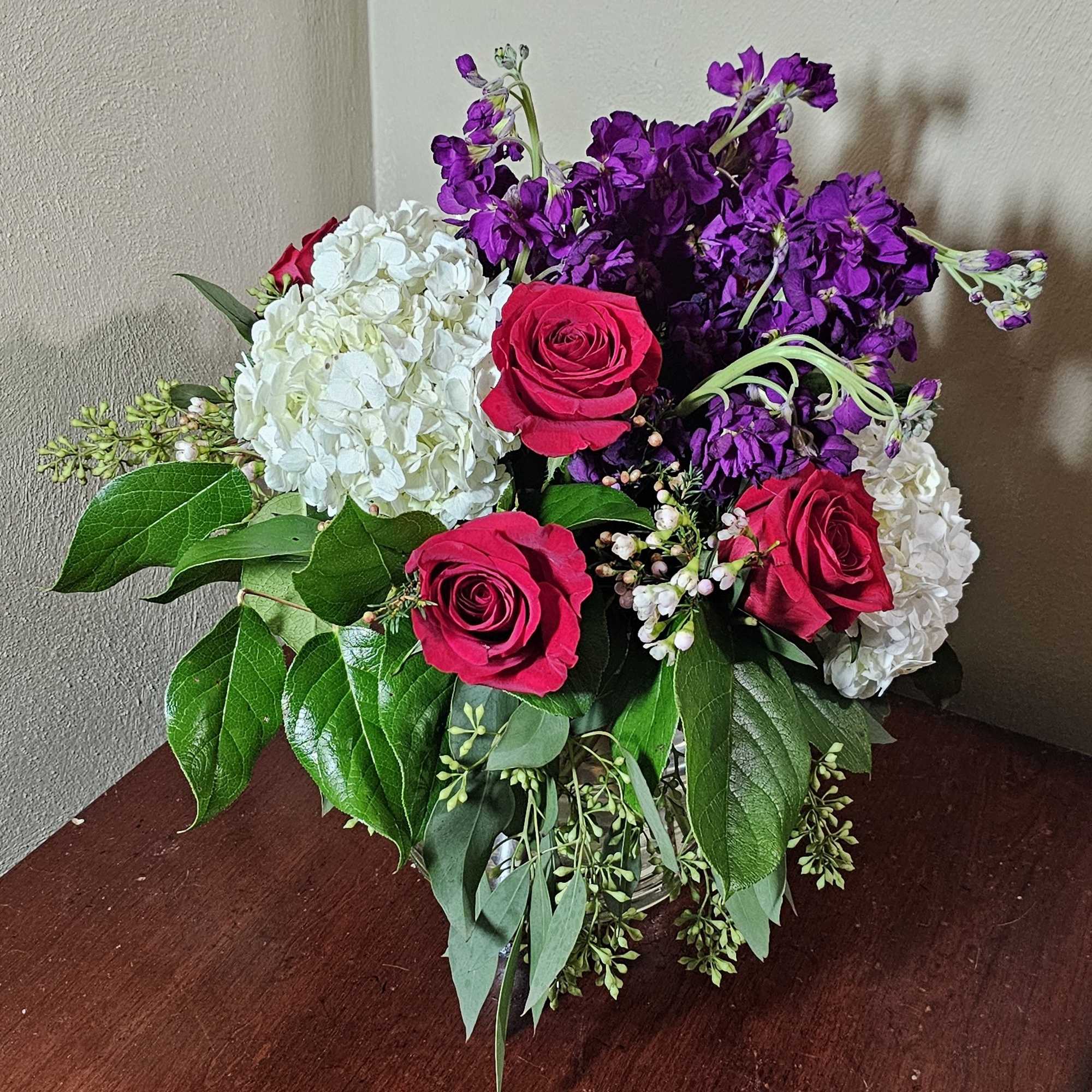 All around arrangement with royal colors of love in a cylindrical glass