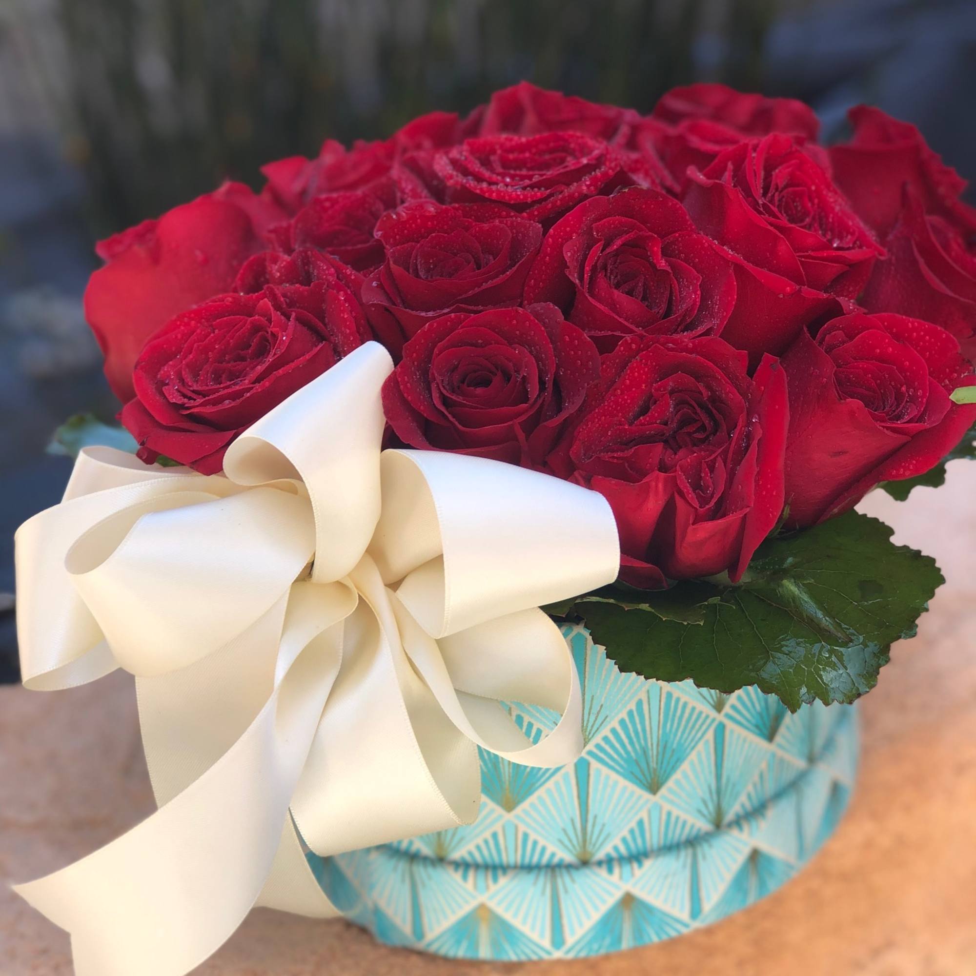 Roses mounded in a beautiful aquamarine, deco style box.