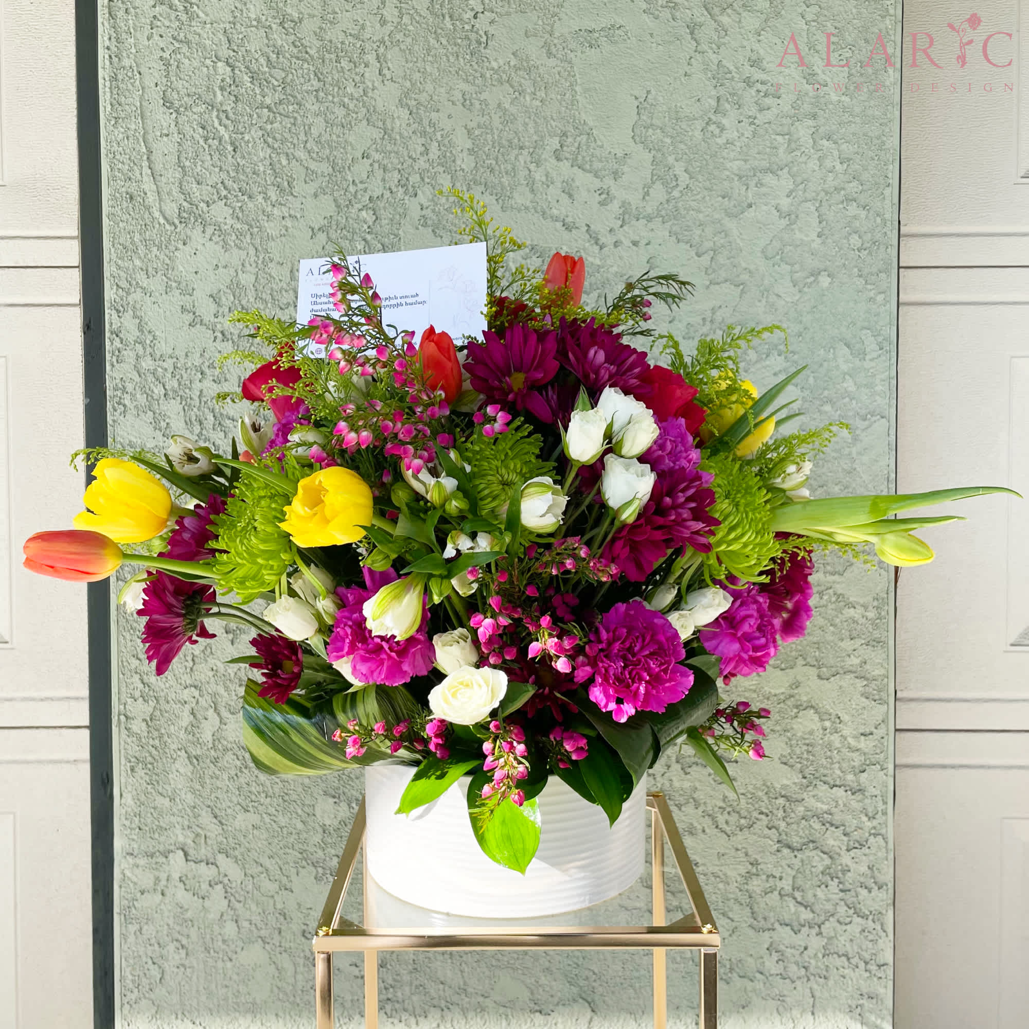 A mix of vibrant fresh spring blooms in a simple white clay