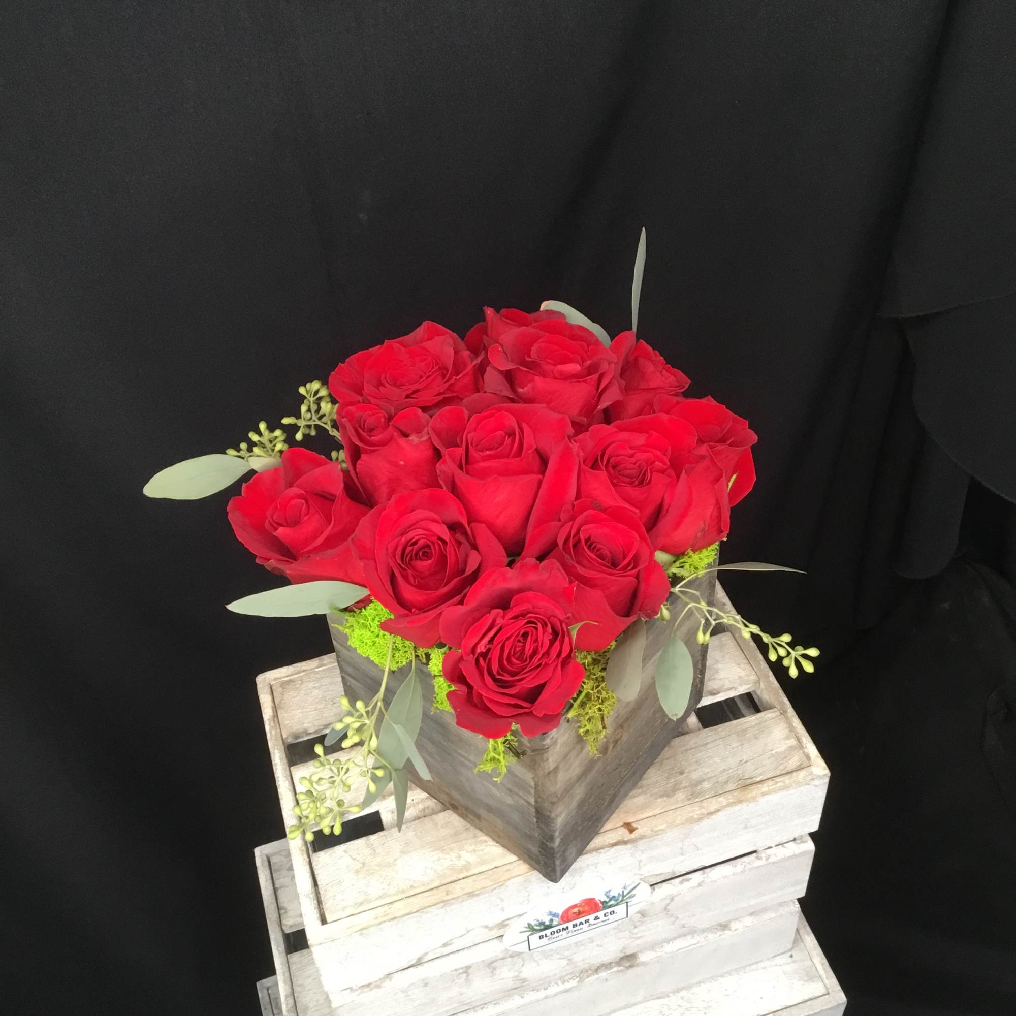 12 rich red roses in a rustic wood box will have your