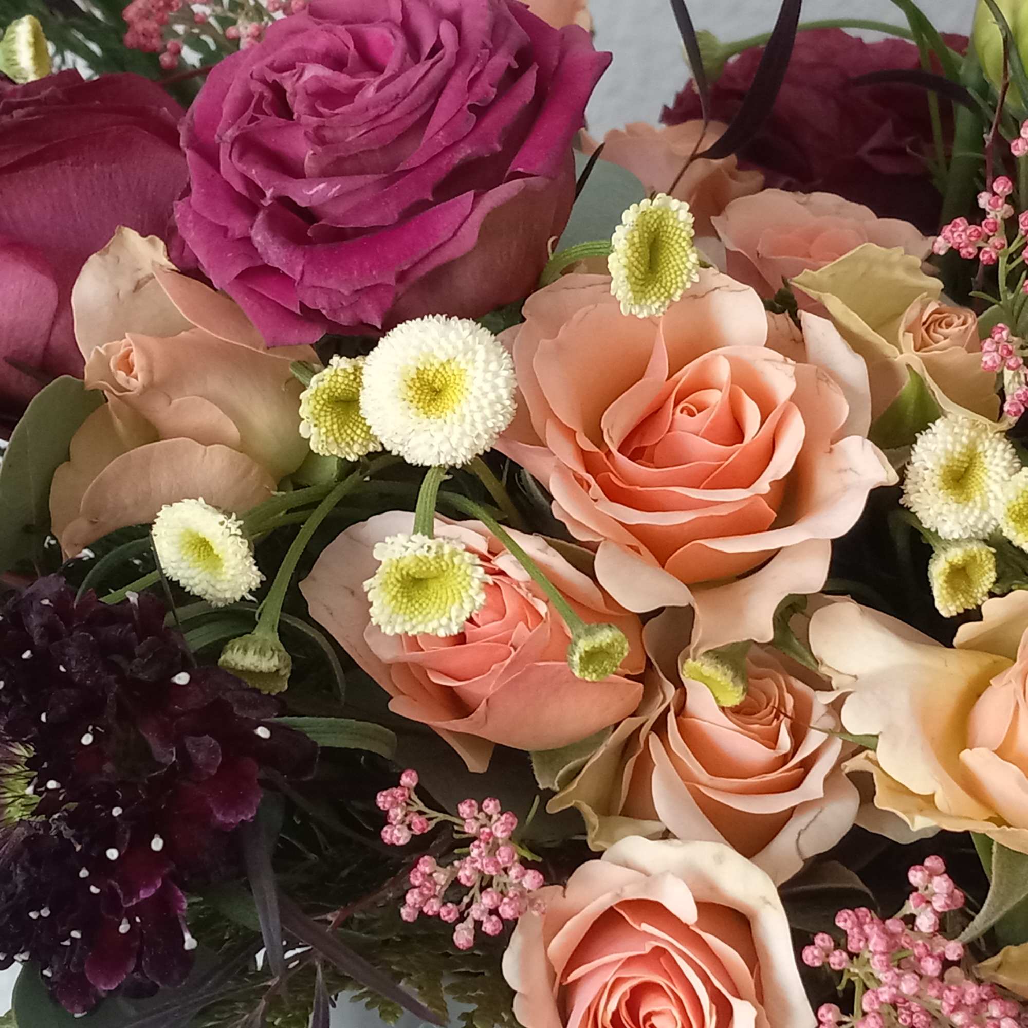 Burgundy lisianthus, and peach spray roses,  all pair organically with assorted