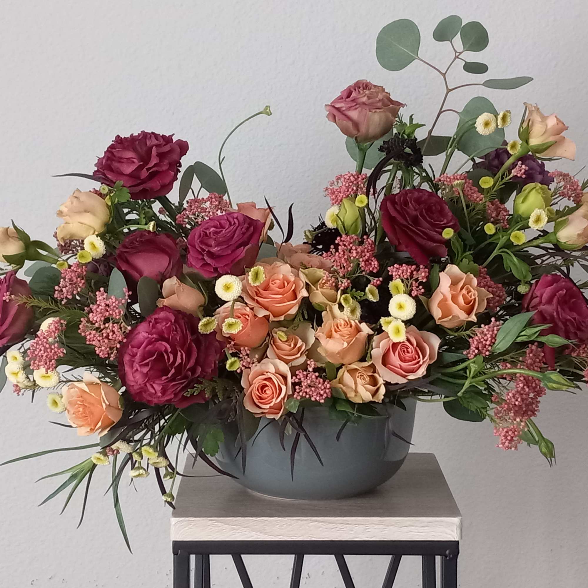 Burgundy lisianthus, and peach spray roses,  all pair organically with assorted