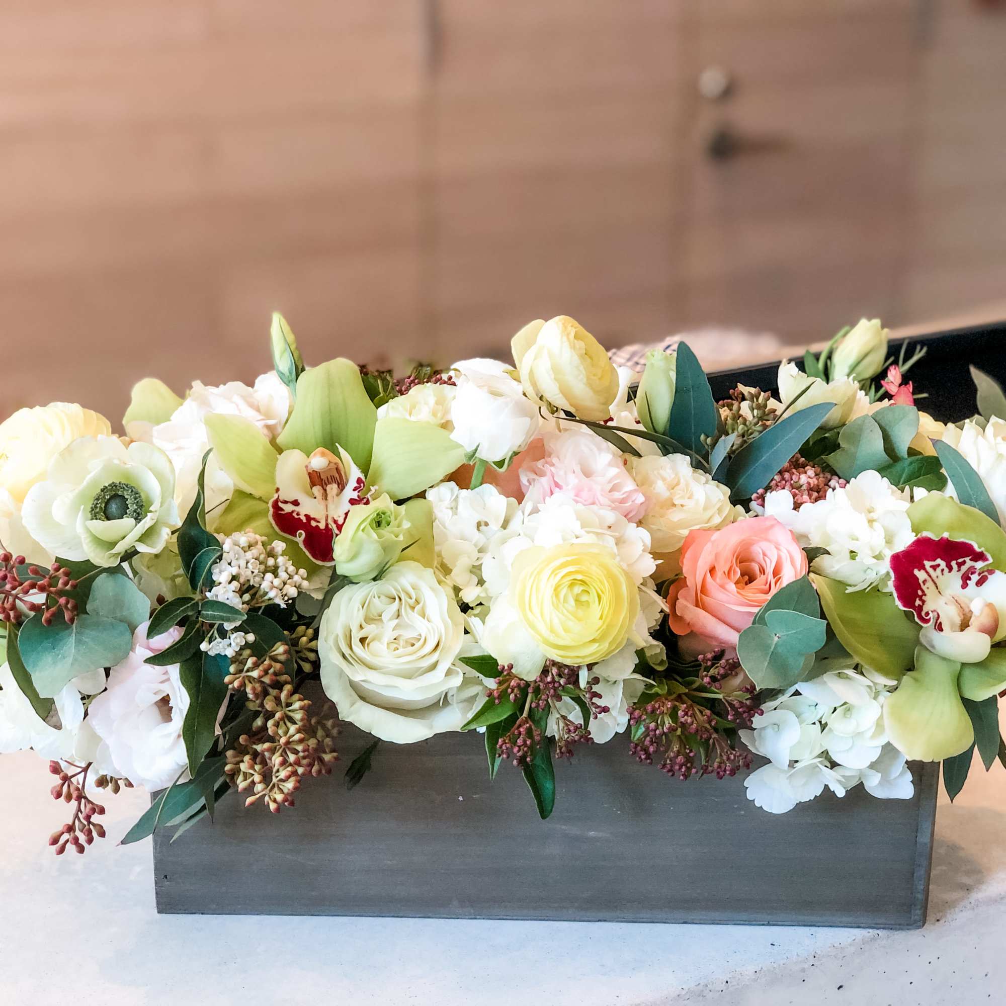 A pleasing combination of beautiful arrangement white roses and Lisianthus ,green orchids