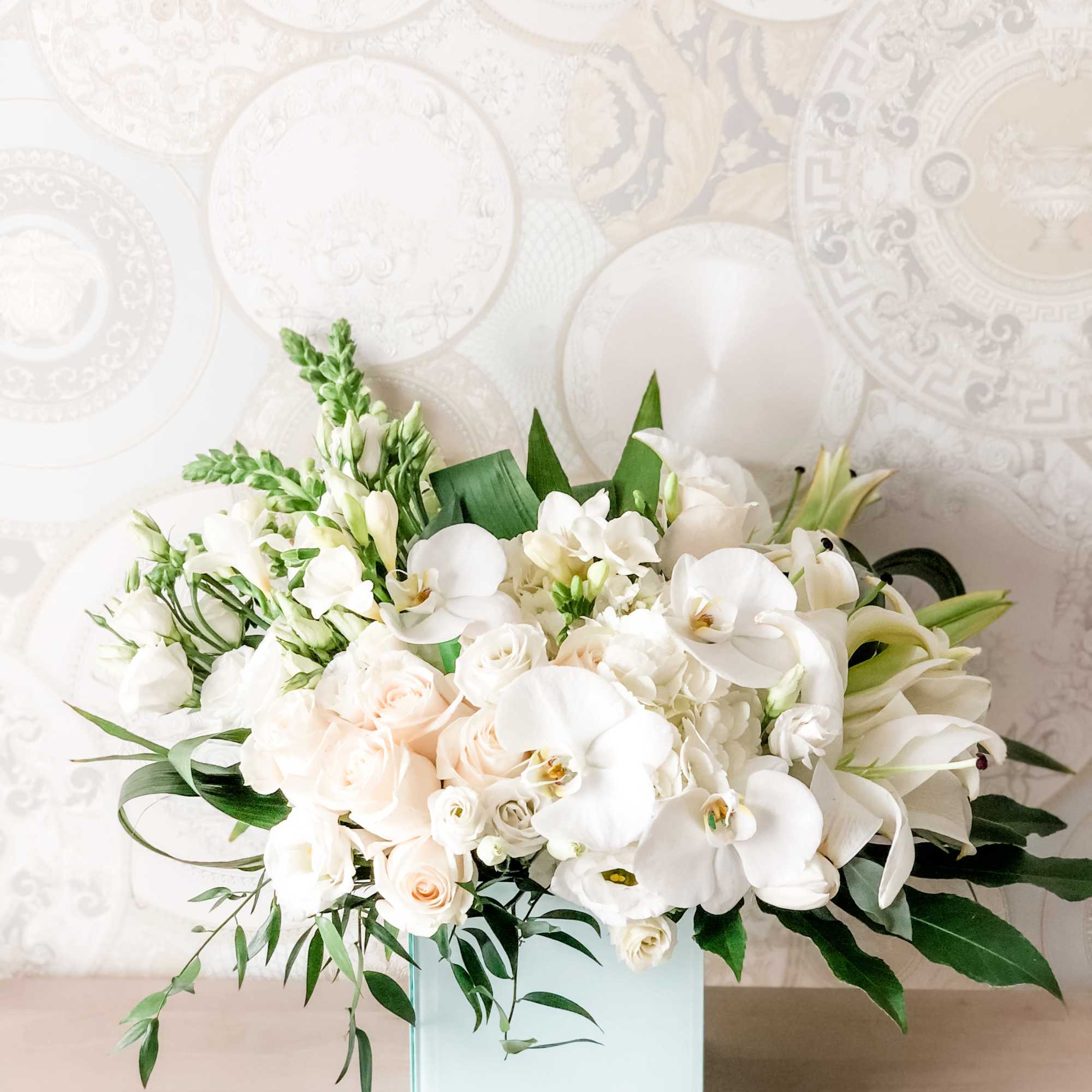 A pleasing combination of Large white arrangement with white orchids, white roses