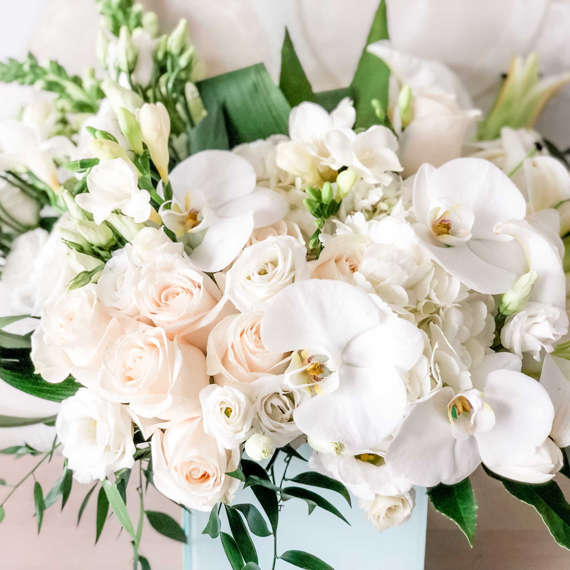 A pleasing combination of Large white arrangement with white orchids, white roses