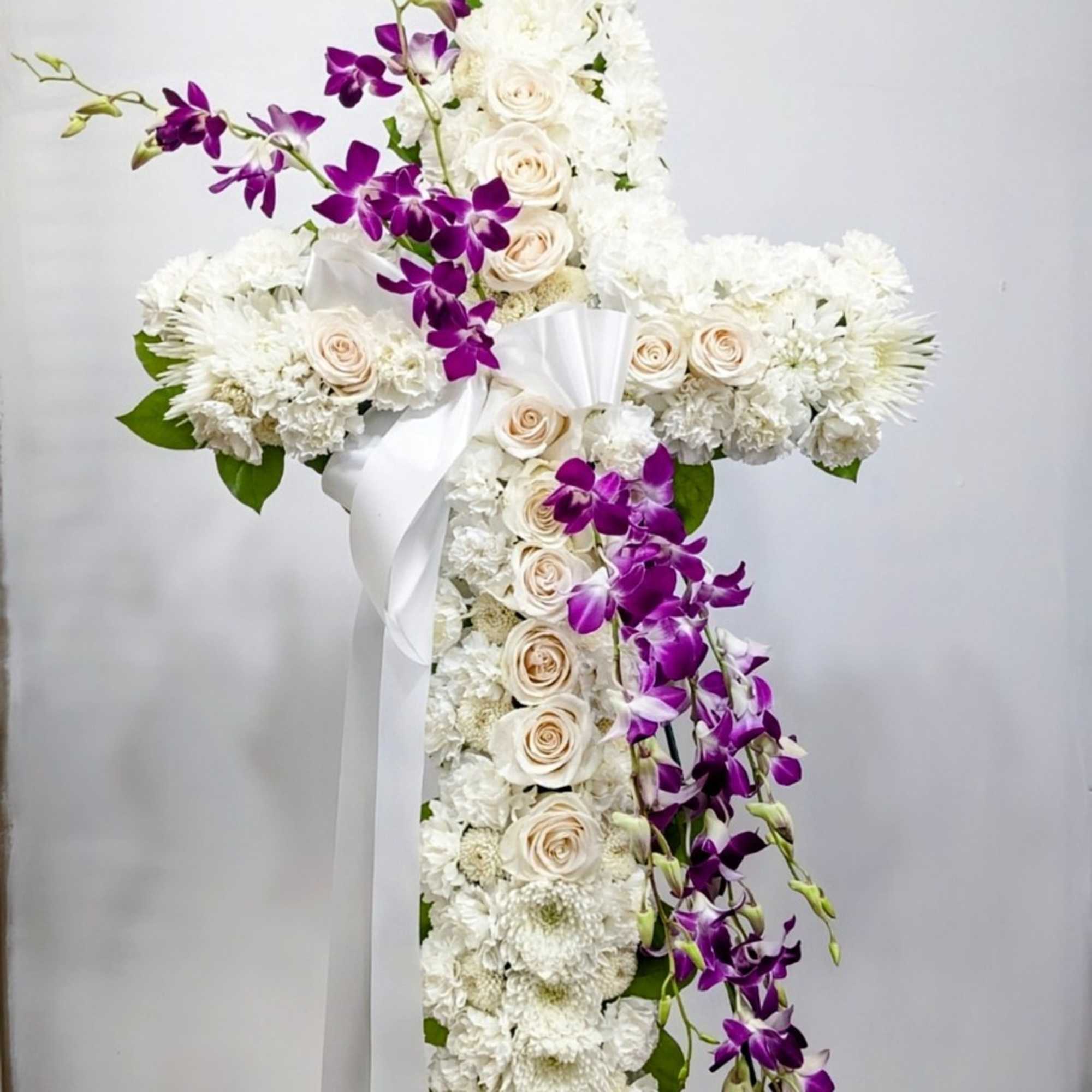 An all white tribute, this white cross funeral spray is pure and