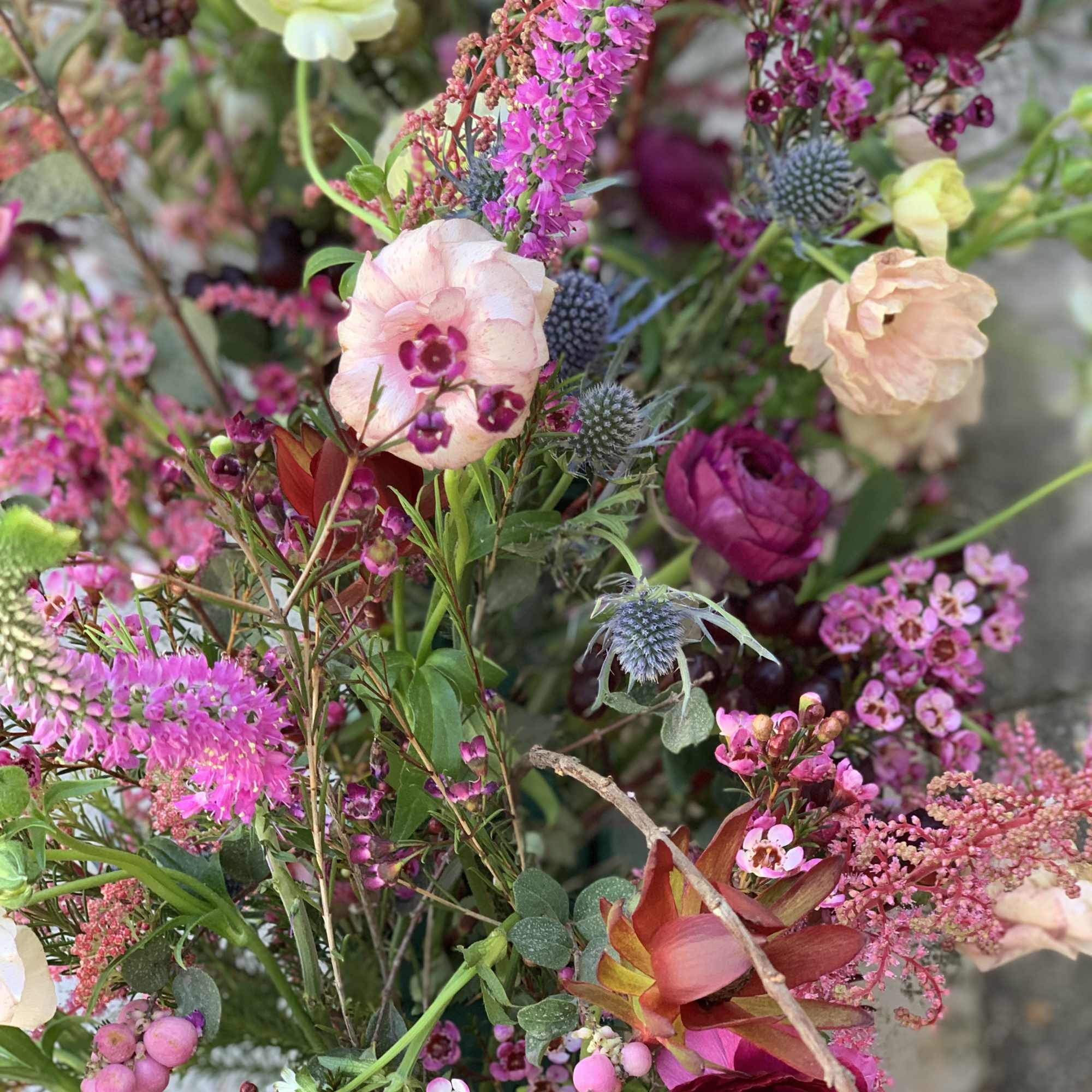 This wild and romantic bouquet of red shades and bold foliage is
