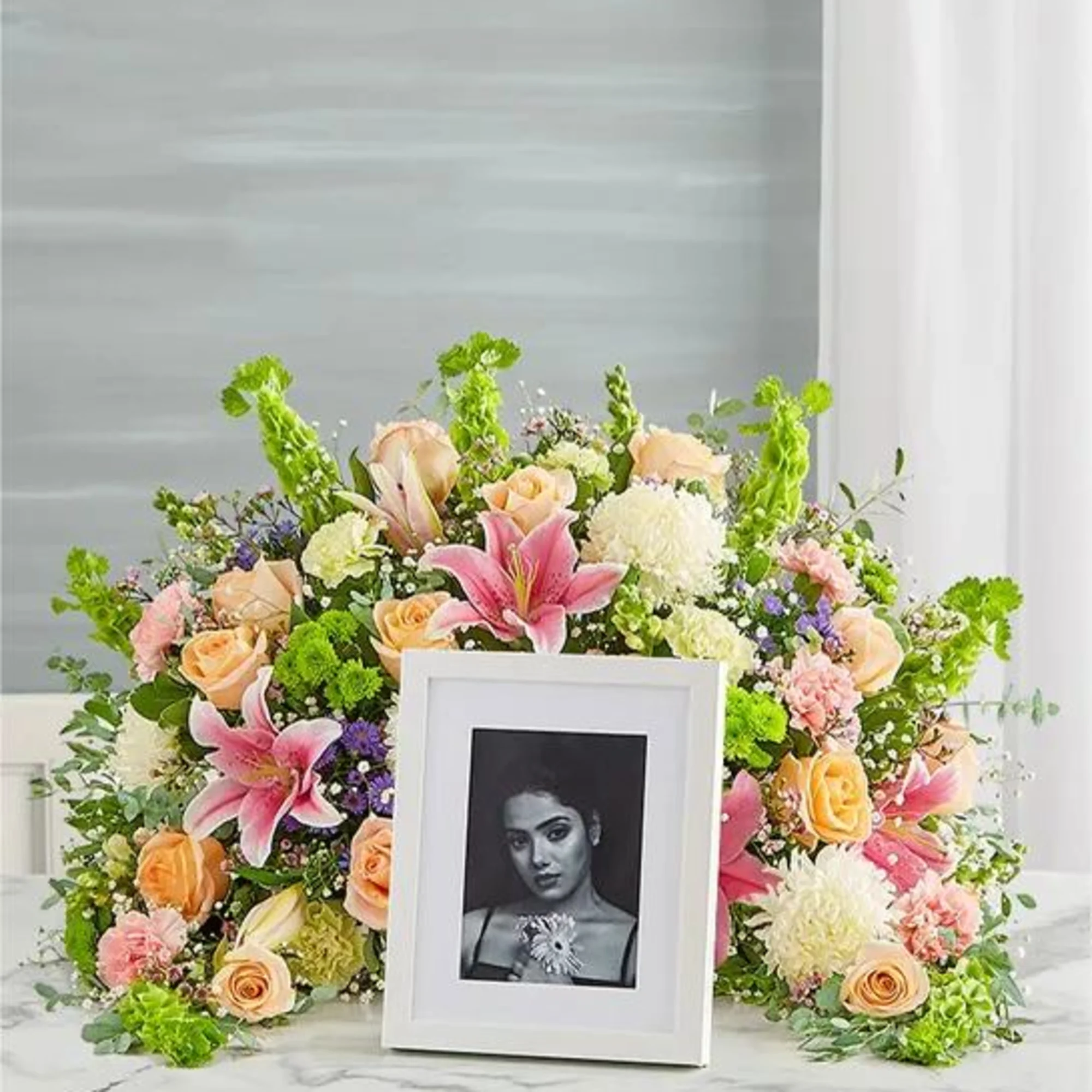 Express your heartfelt condolences with a beautiful floral tribute. Our crescent shaped