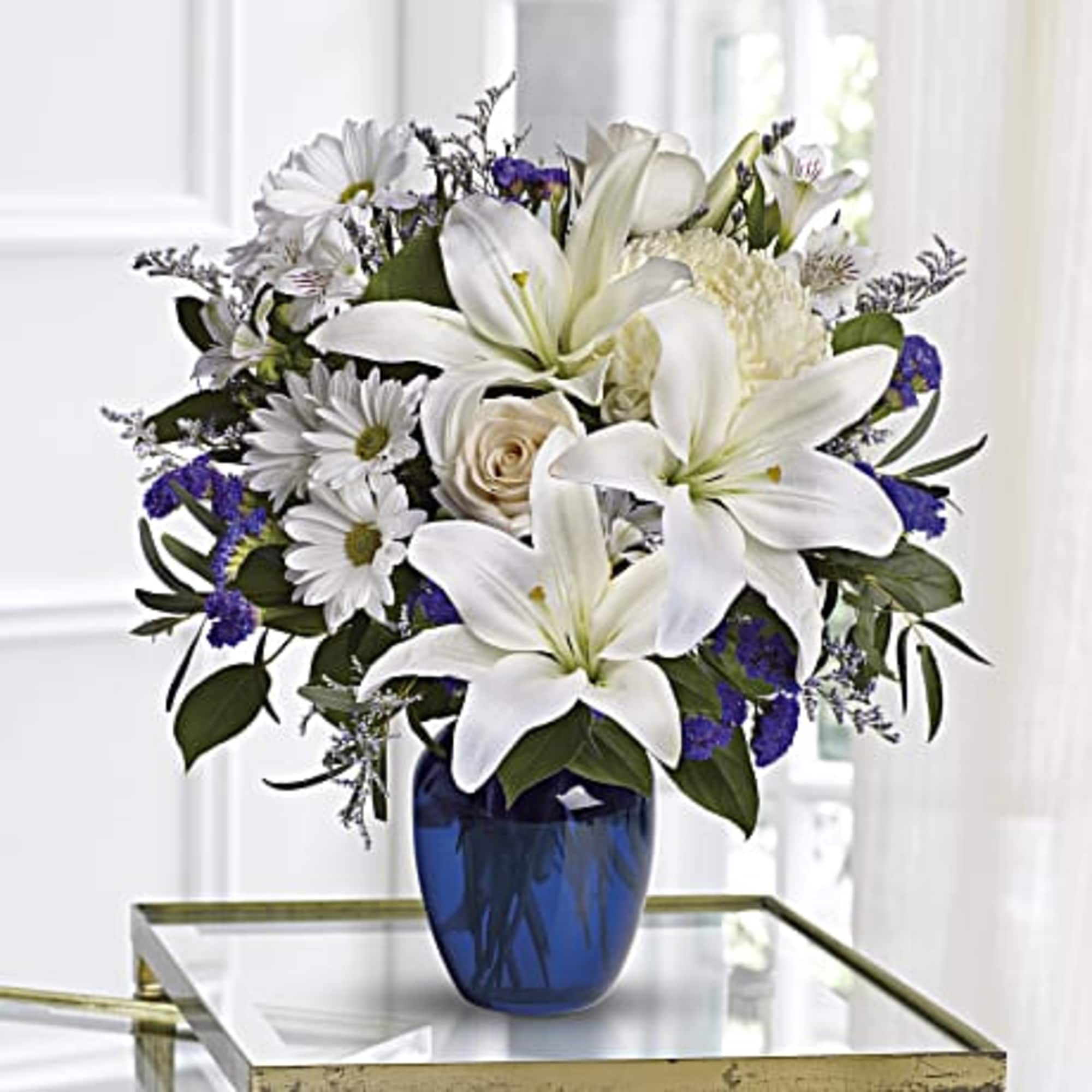 Beautiful blooms such as cr&egrave;me roses, white lilies and alstroemeria along with