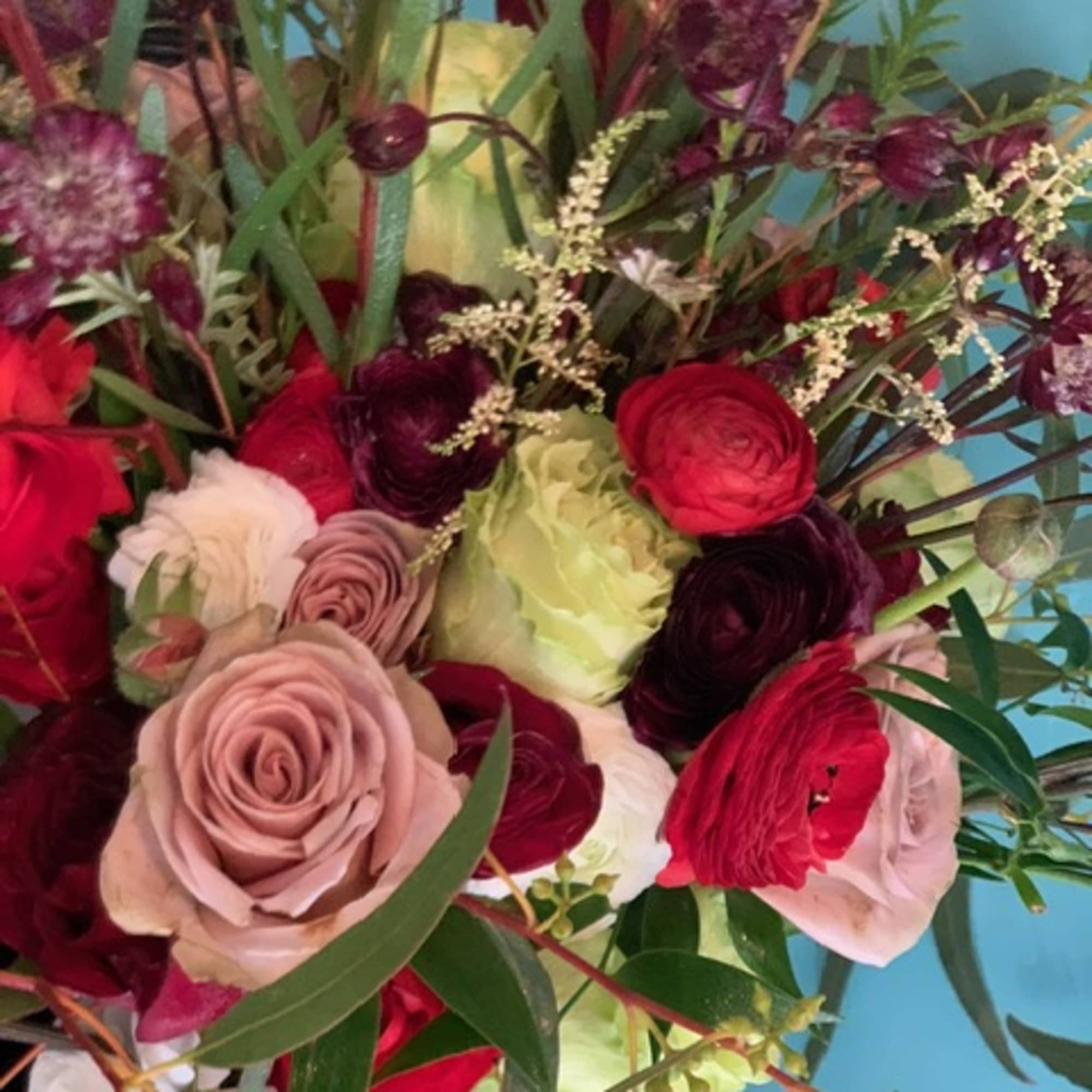 This striking bouquet is filled with drama and color. The deeply romantic