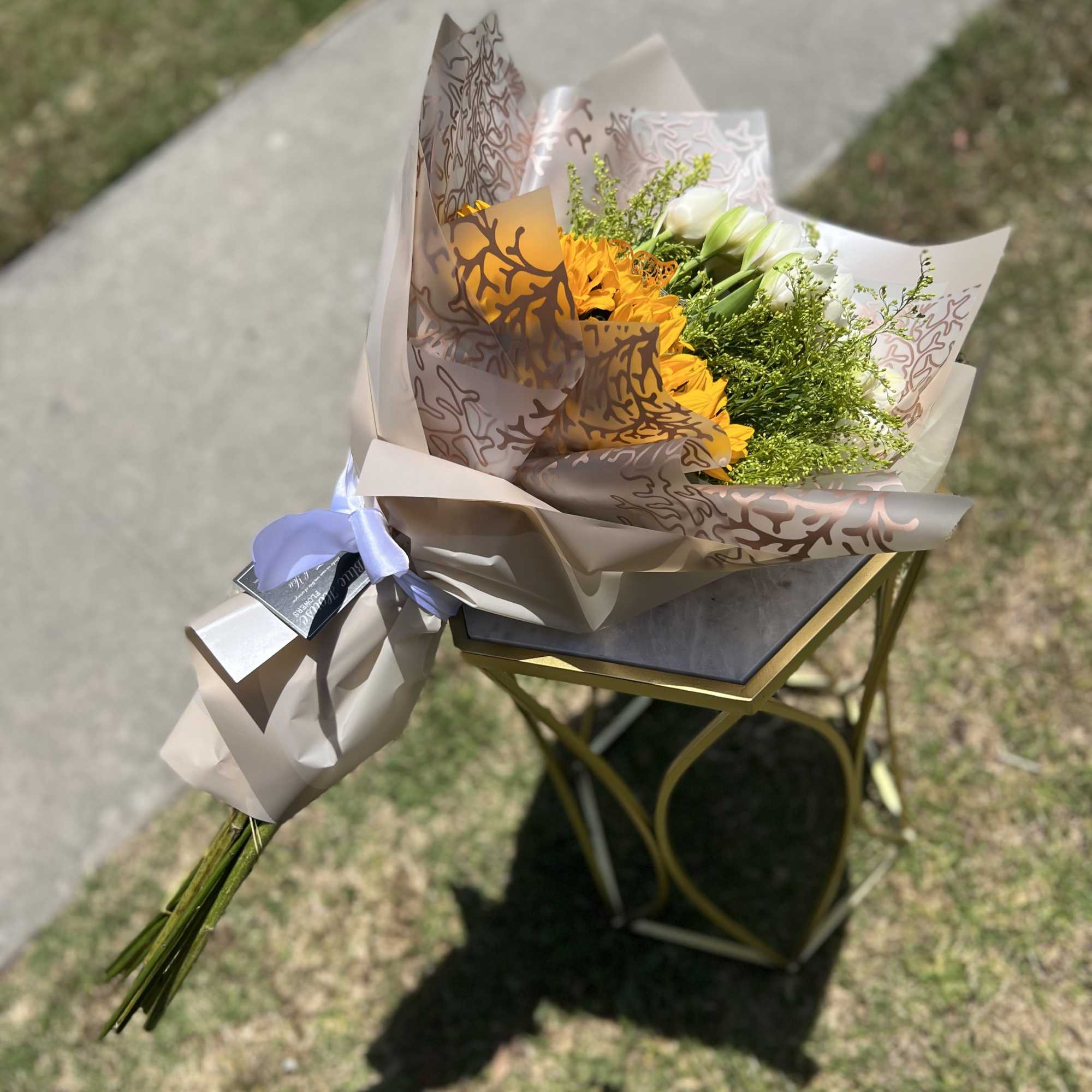 10 White Tulpis and 5 Sunflowers. Wrapped Champagne Paper.