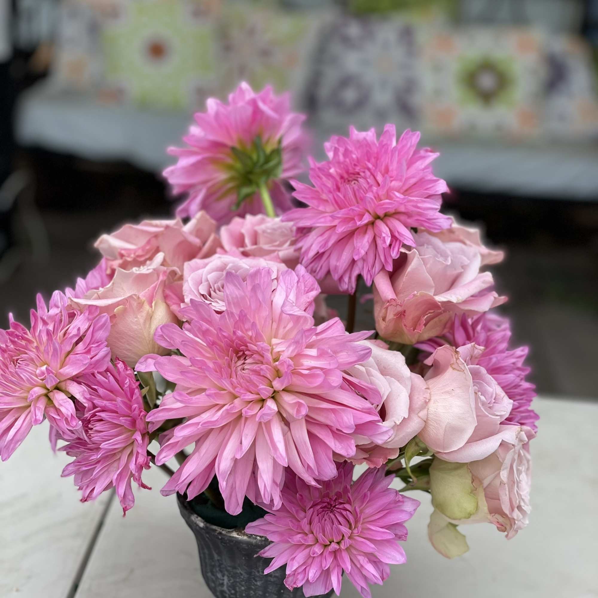 This compact composition of Roses and Dahlias boasts a bold look, shining