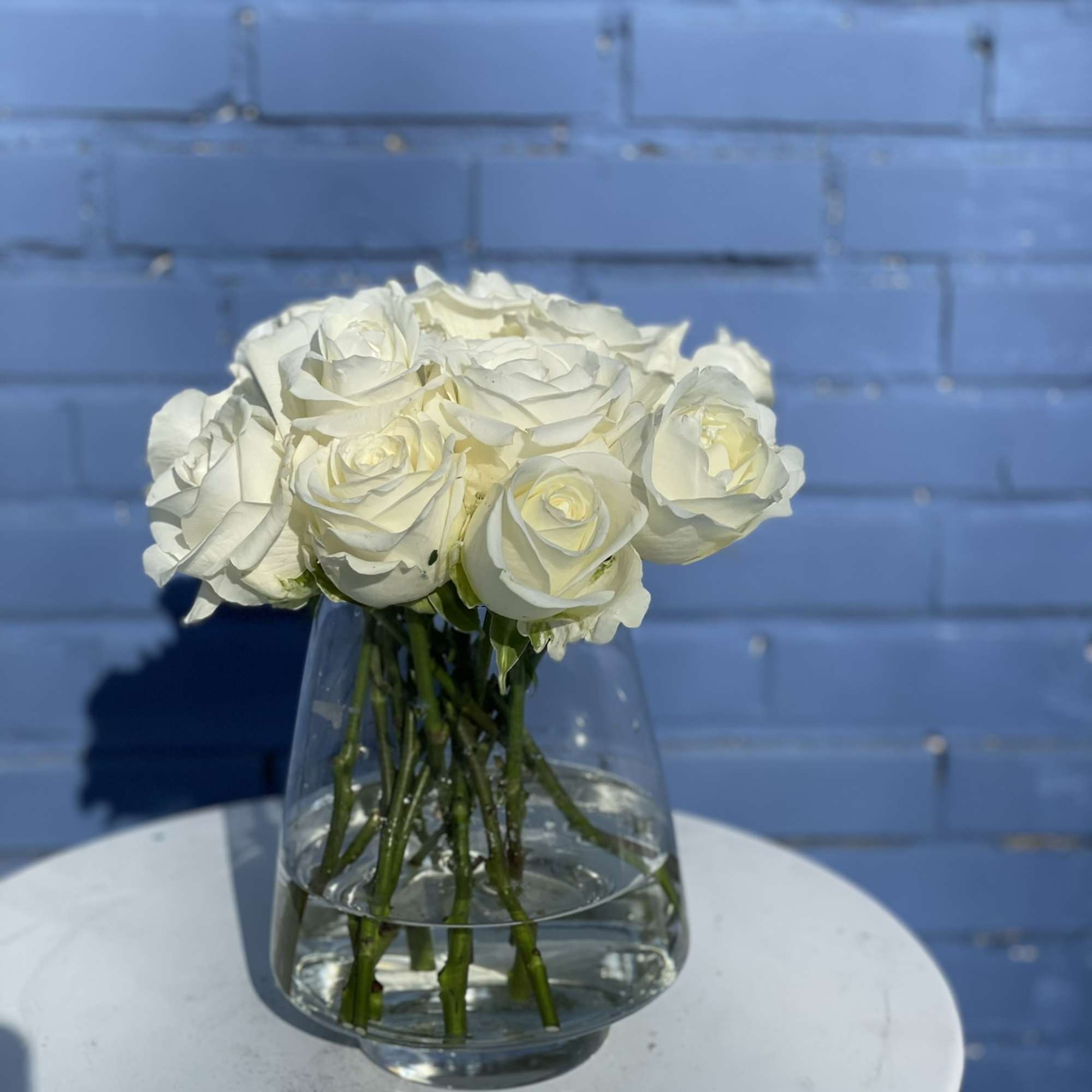 13 Beautiful, timeless long stem white roses arranged in an elegant vase