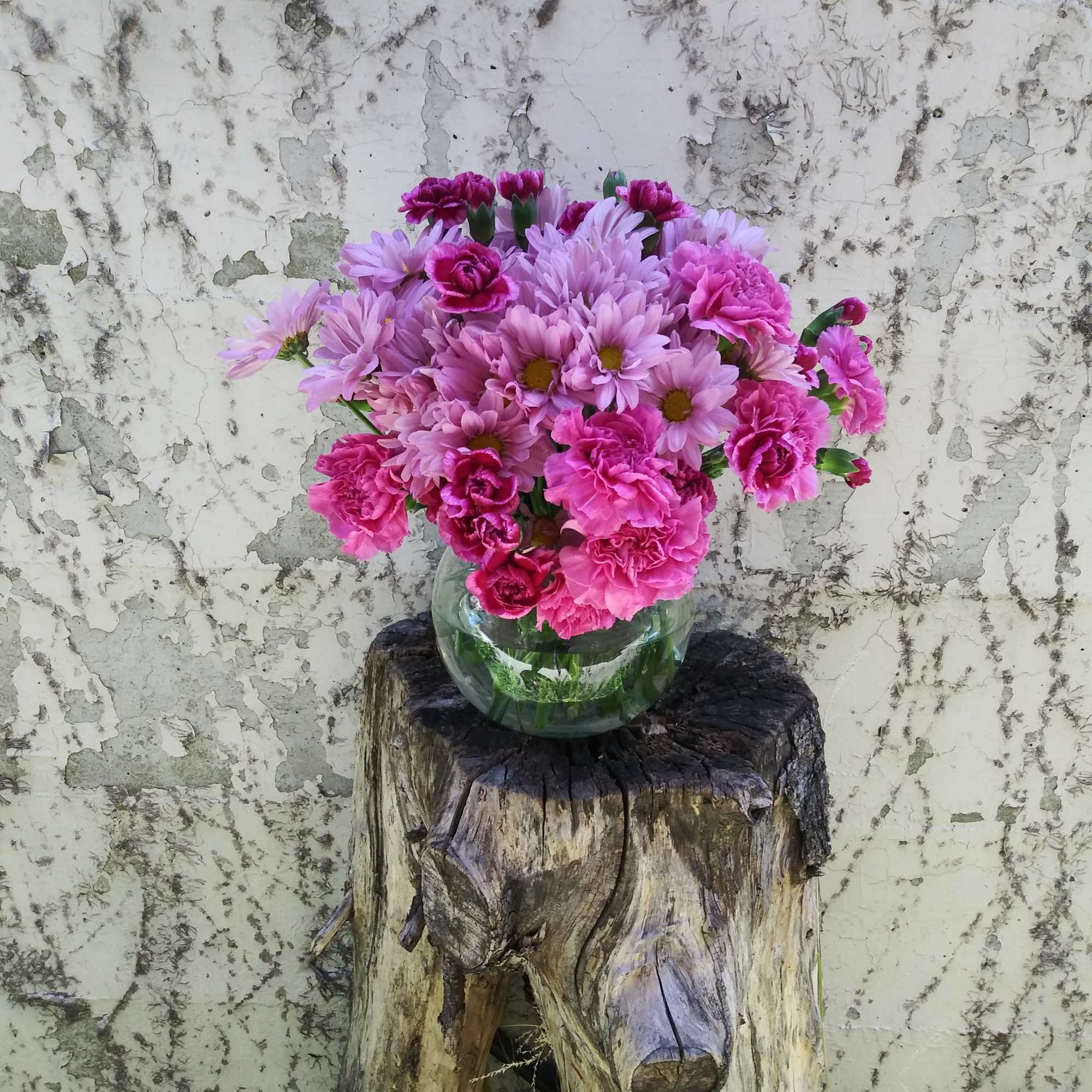 A mixed flowers vase of lavender and purple carnation and daises. 