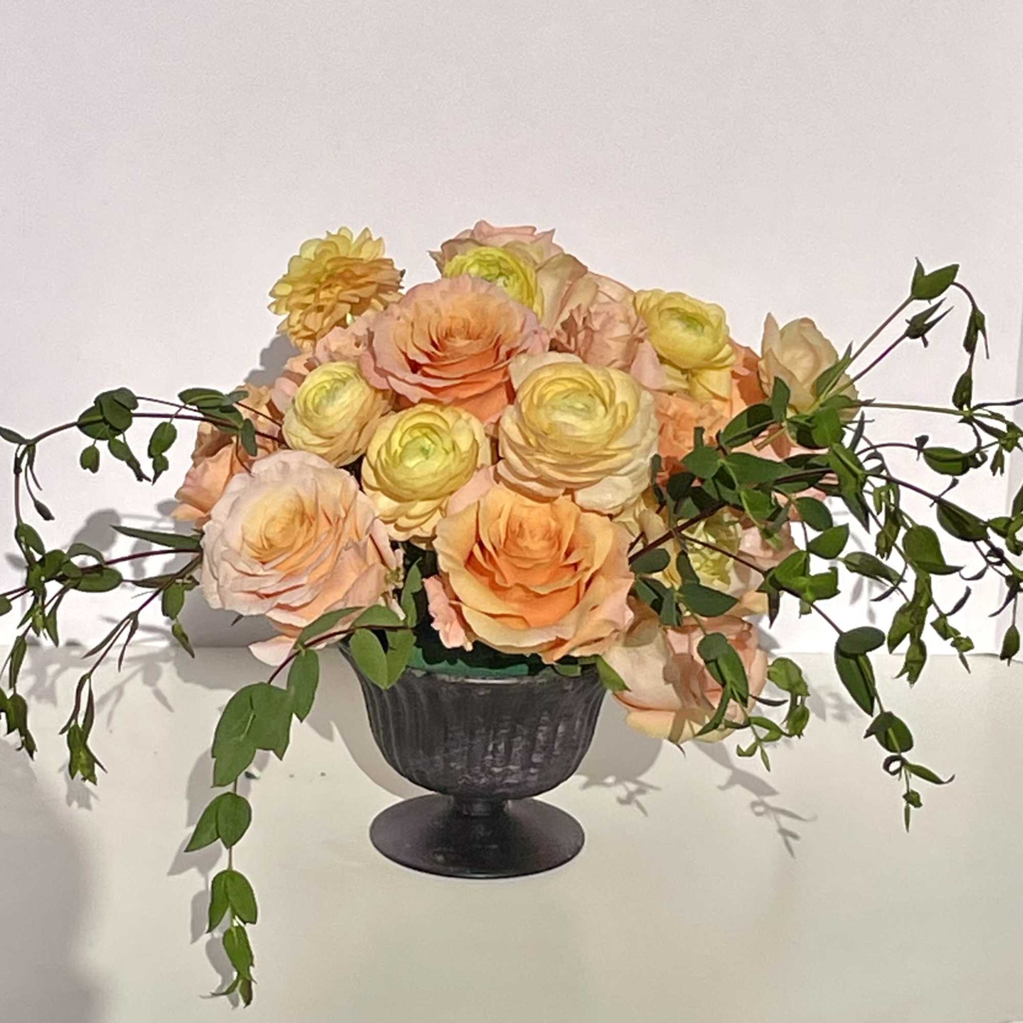 This compact arrangement of ranunculus, roses, and garden roses is full of