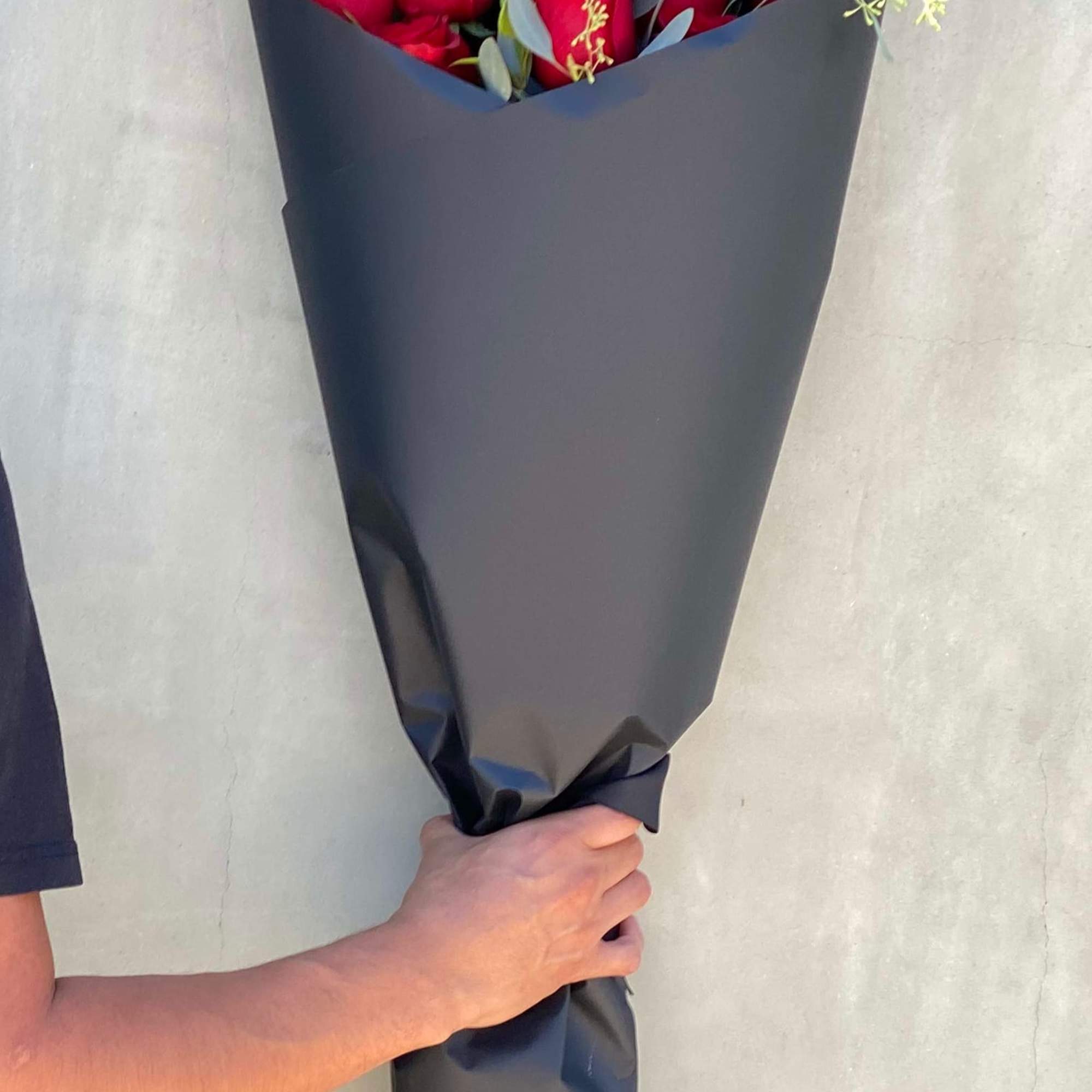 Lovely long stem red rose with greenery wrapped in our limited black