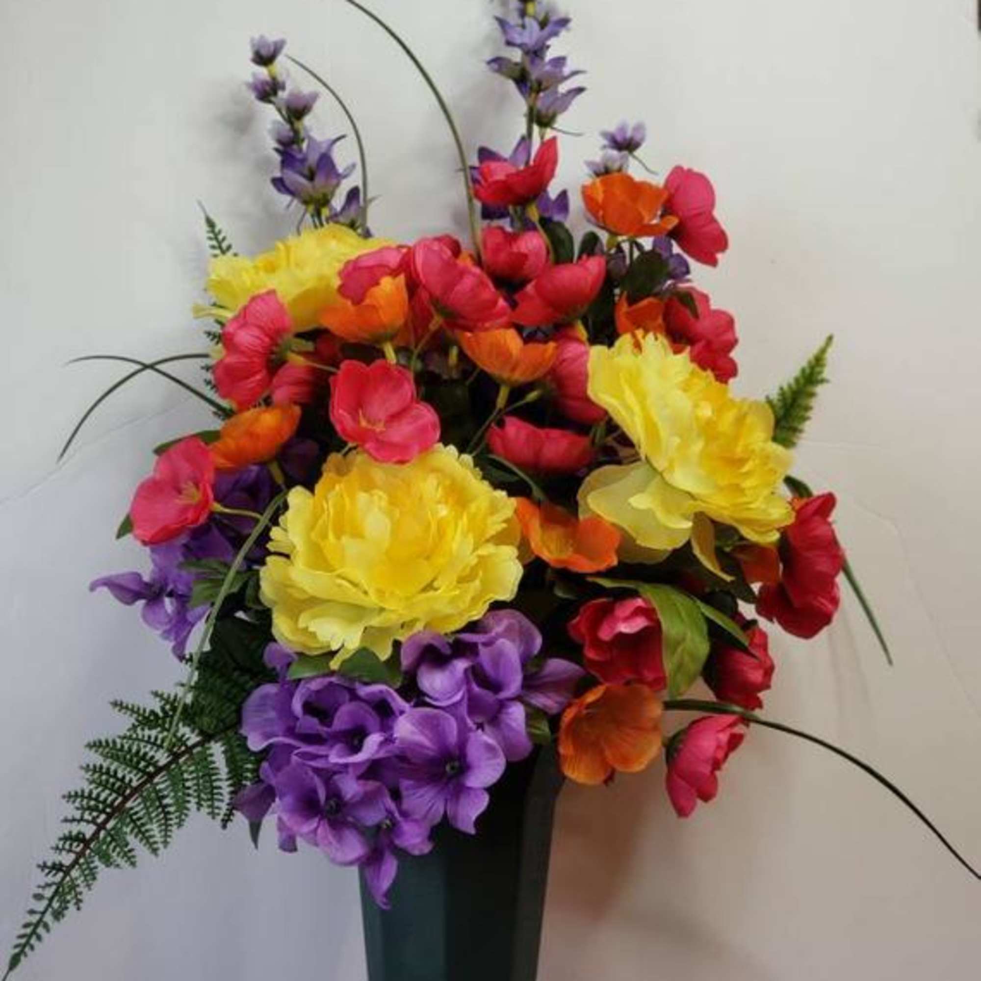 Remember your loved one with a beautiful silk flower arrangement. Created with
