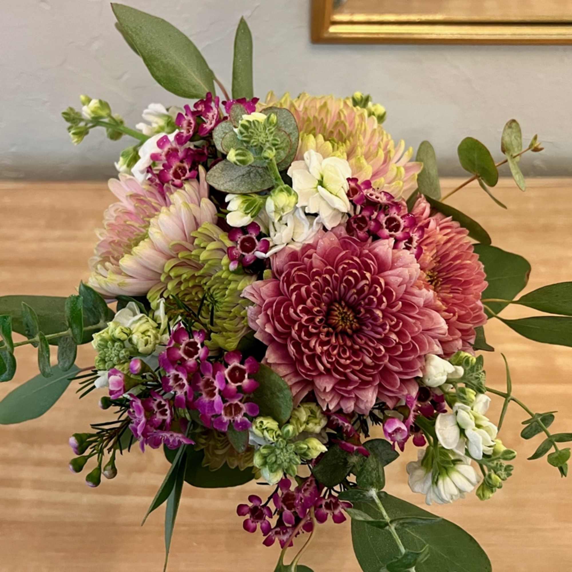 The Isabella handheld bouquet consists of assorted flowers of mauve, purple, blush