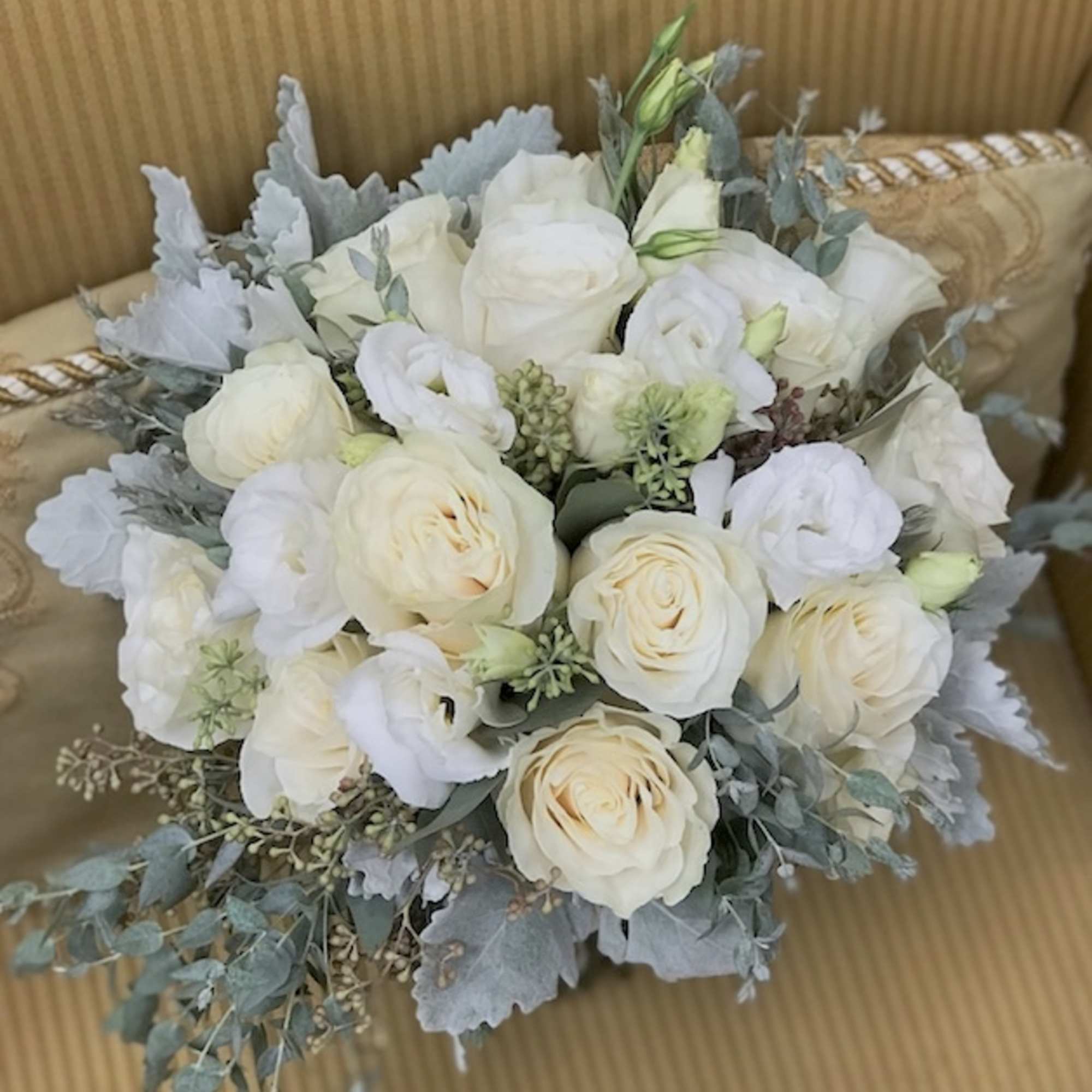 White lisianthus, cream roses,seeded eucalyptus, dusty miller and dusty miller lace.