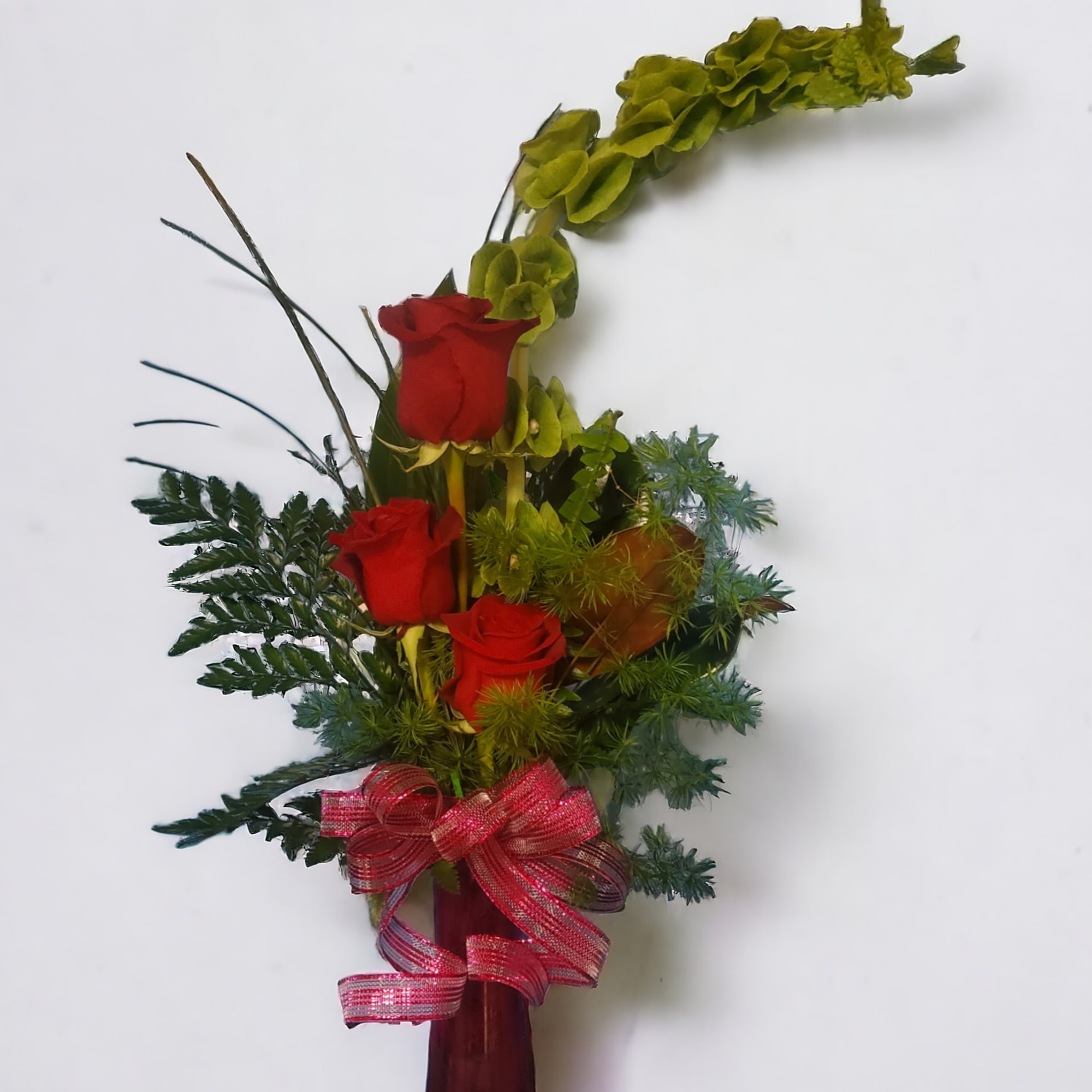 Roses and mixed foliage in a modern bud vase.  Roses and mixed foliage in a modern bud vase.