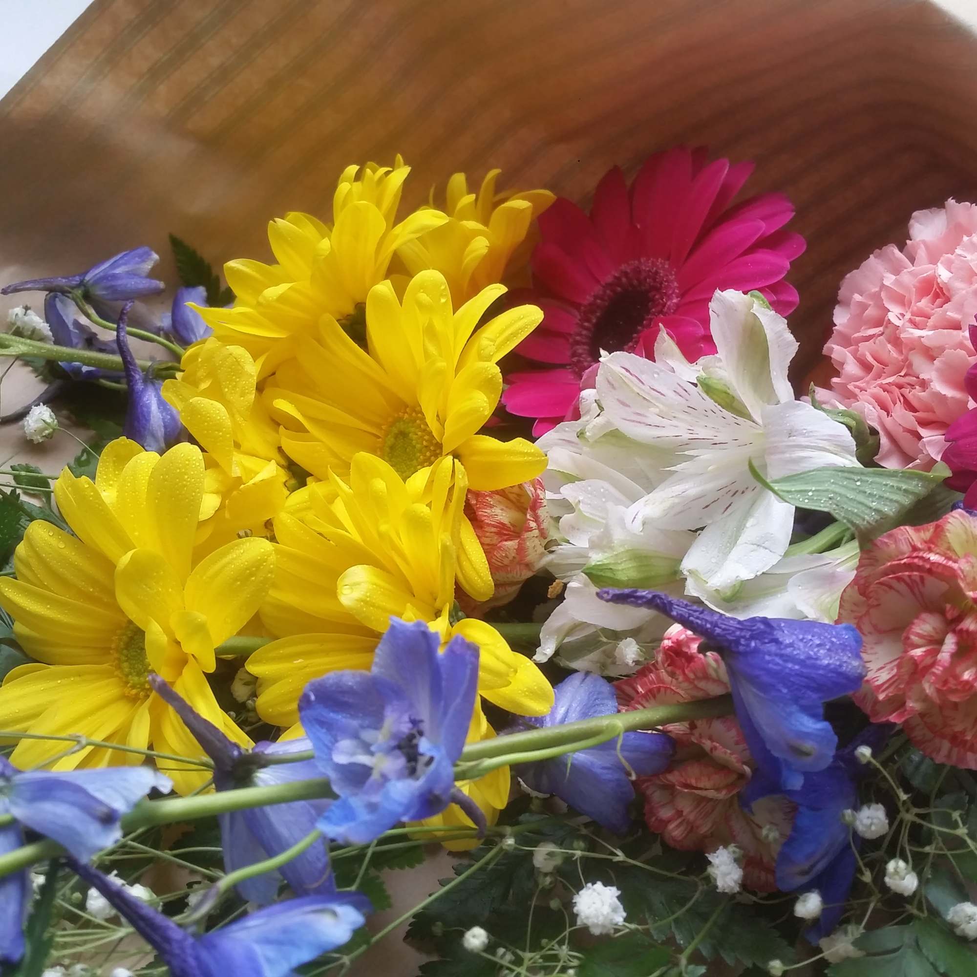 A lovely assortment of fresh cut flowers wrapped in paper and tied