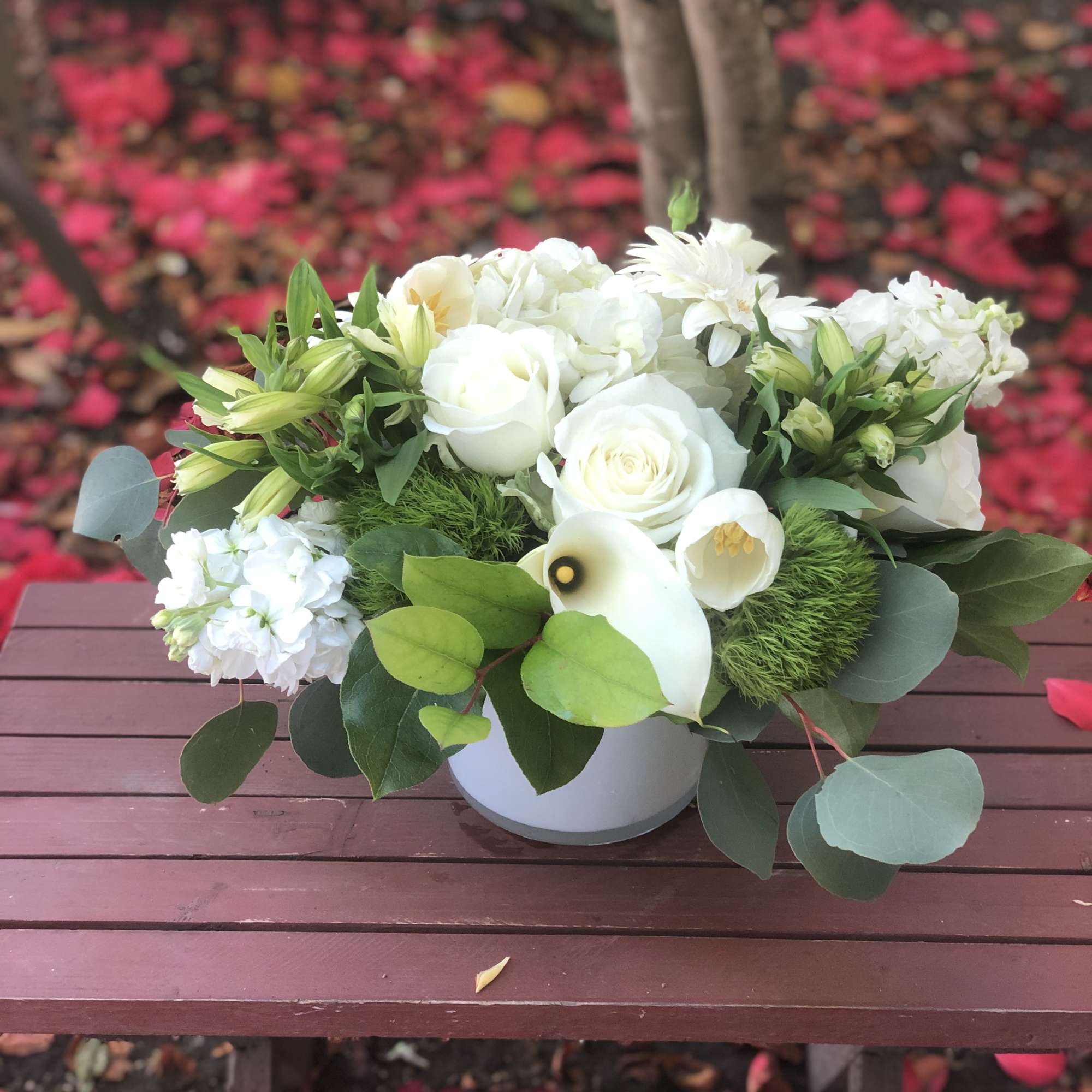 This arrangement contains gerbera daisies, roses, stock, and other seasonal blooms. APPROXIMATE