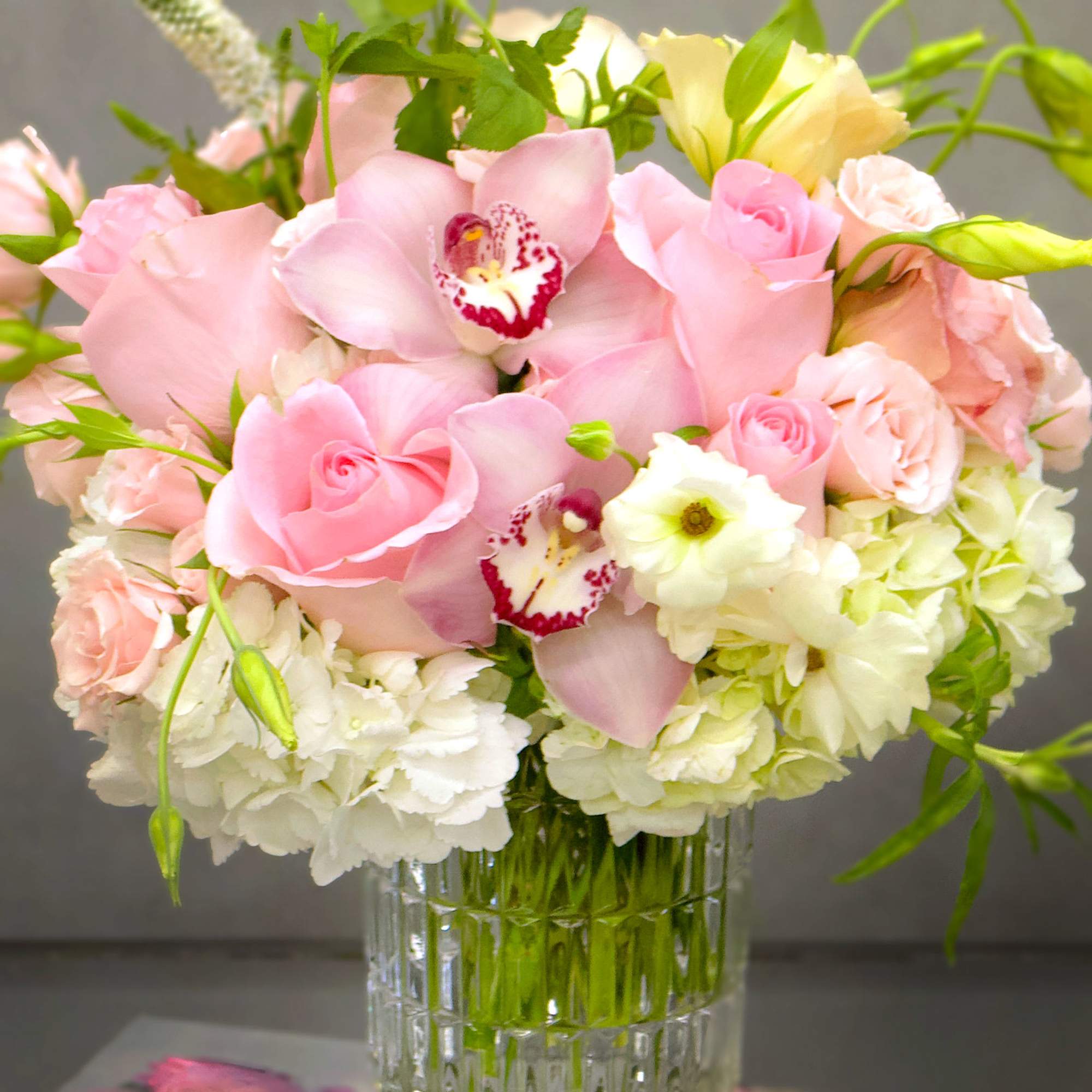 Admire the beauty of a delicate arrangement featuring soft pink roses, luxurious