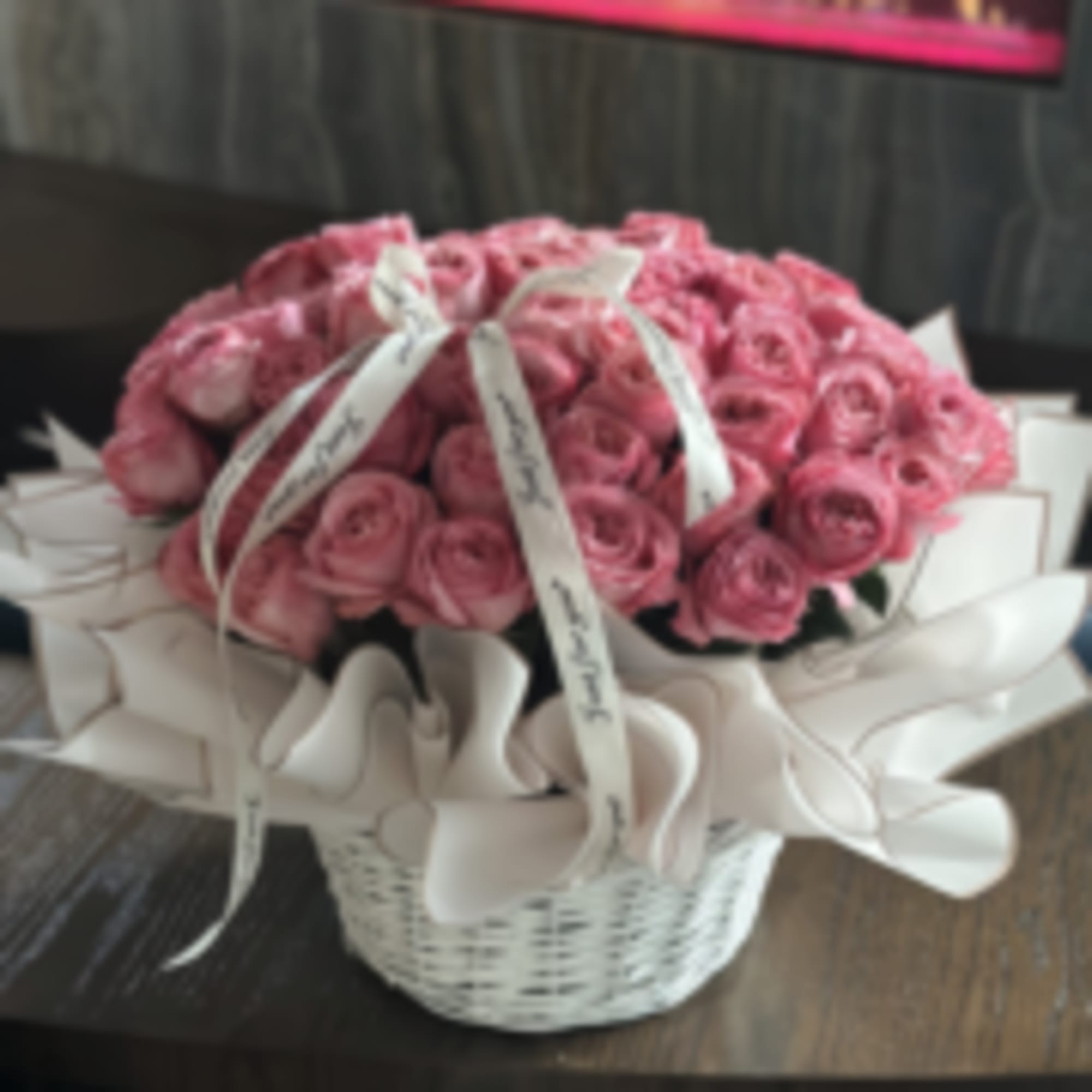 A white basket adorned with pink peony roses exudes elegance and charm.