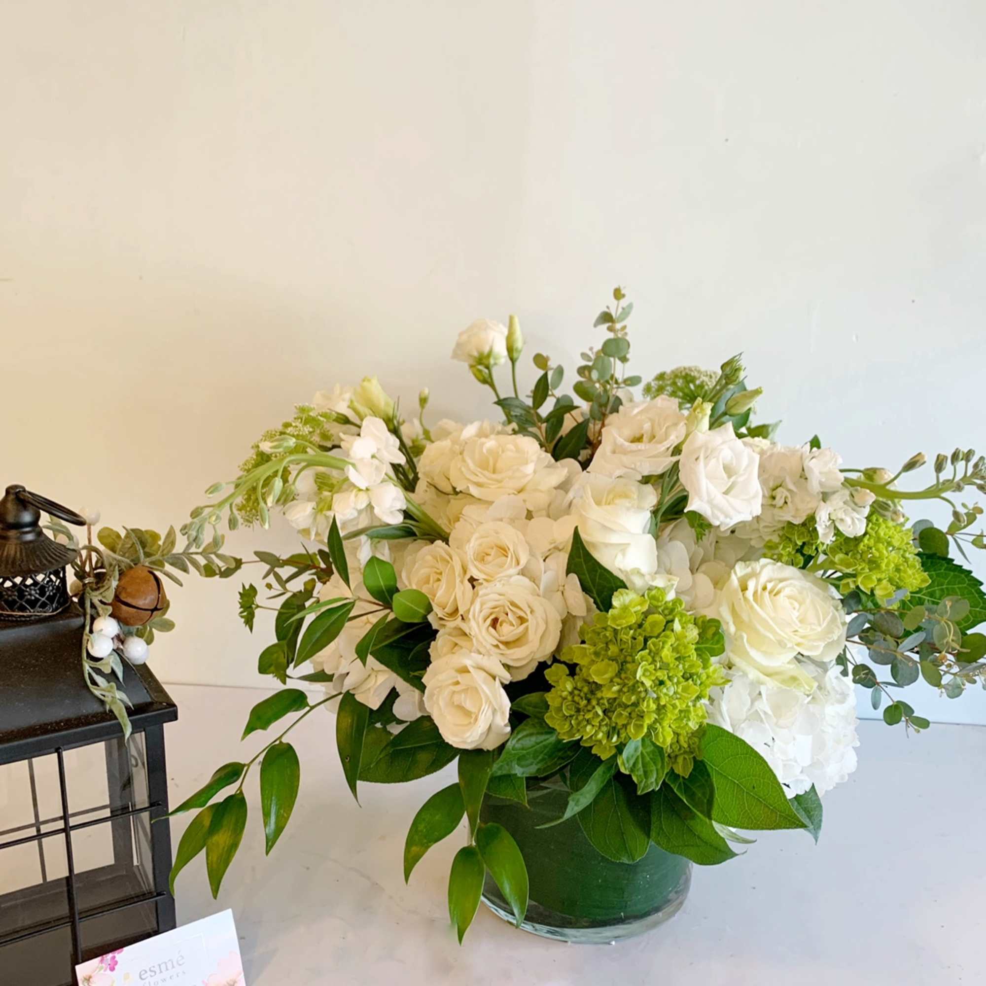 A lush, all white arrangement of roses, hydrangeas, lisianthus, and other seasonal A lush, all white arrangement of roses, hydrangeas, lisianthus, and other seasonal