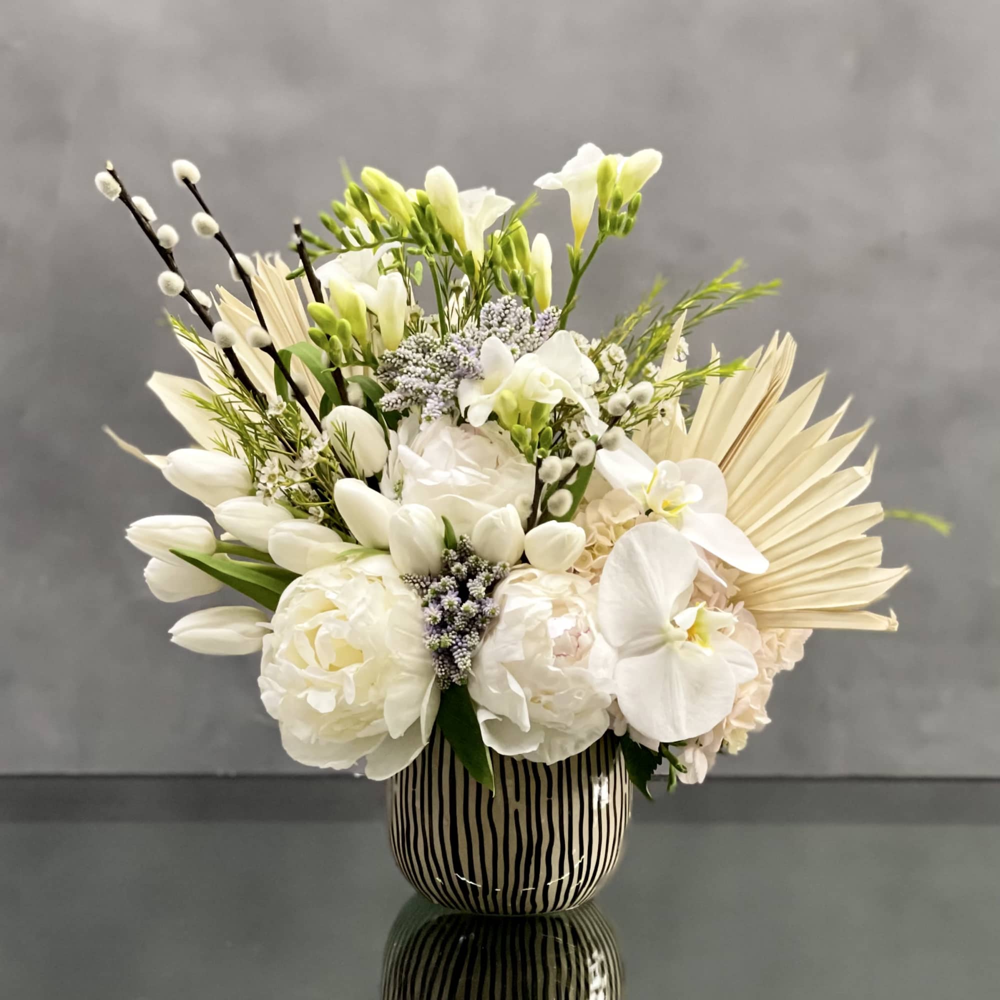 This arrangement is made with a designer&#039;s choice array of seasonal white