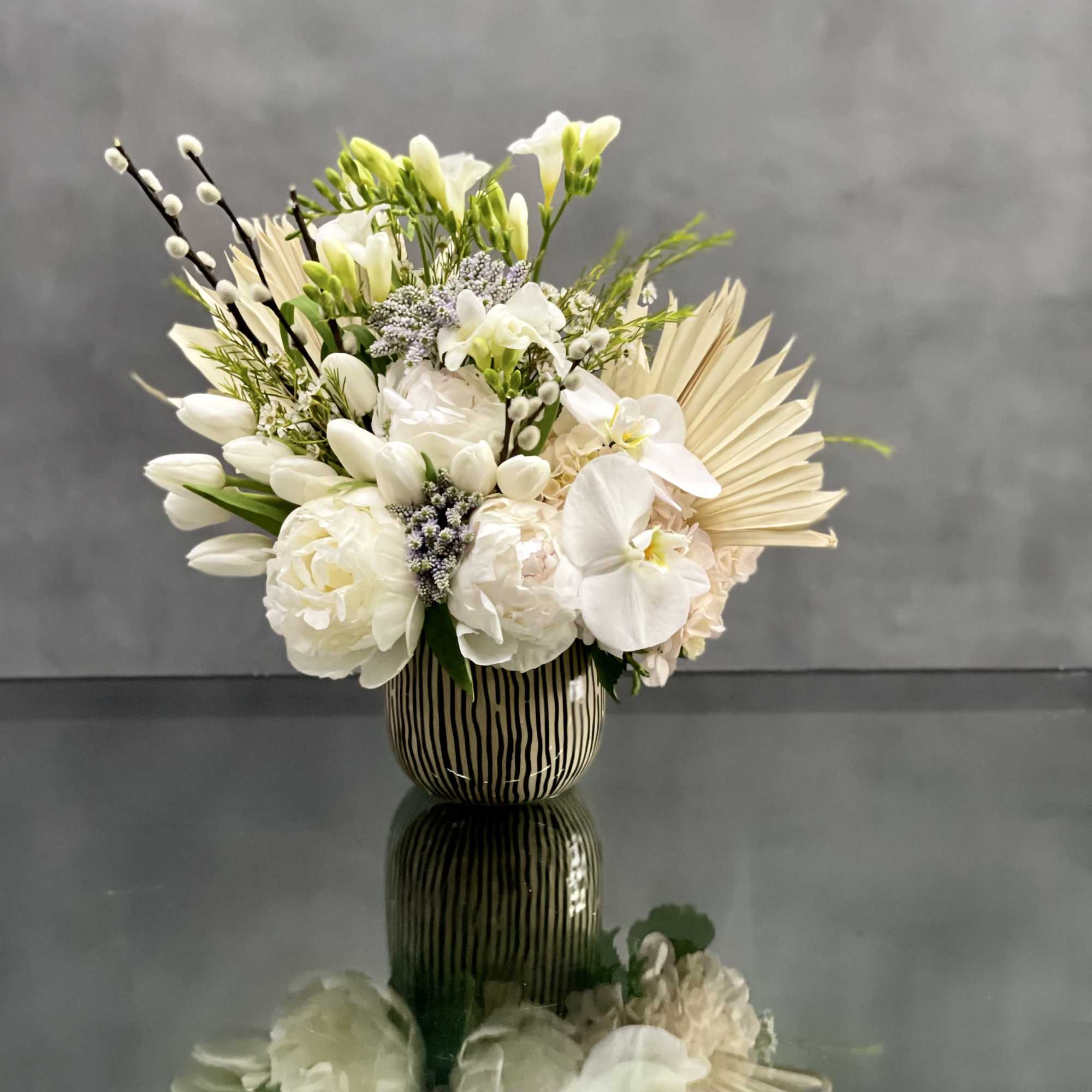 This arrangement is made with a designer&#039;s choice array of seasonal white