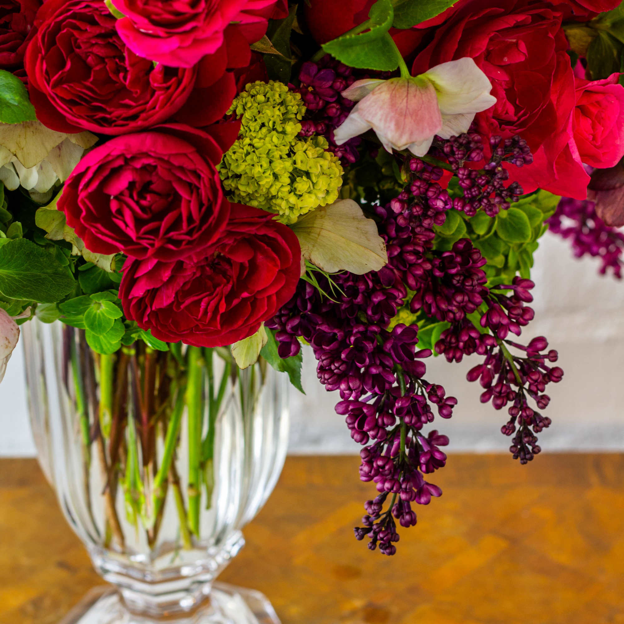 The floral arrangement in the tall crystal vase is truly exquisite. It