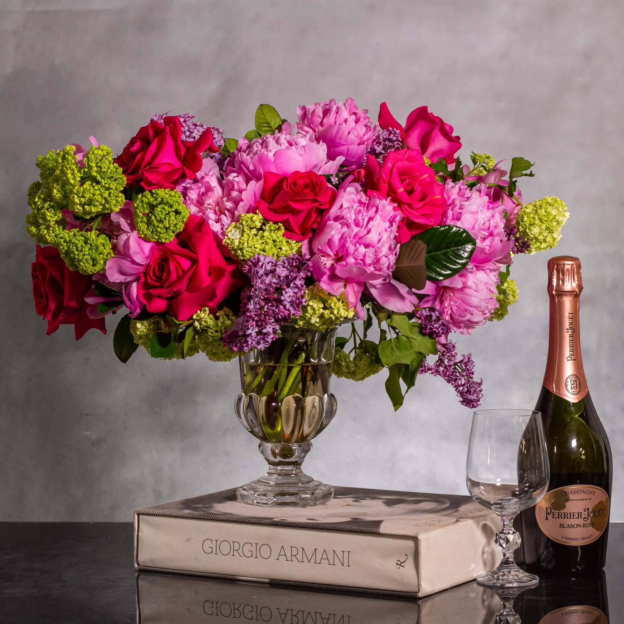 The floral arrangement is a sight to behold, showcasing large-headed pink peonies