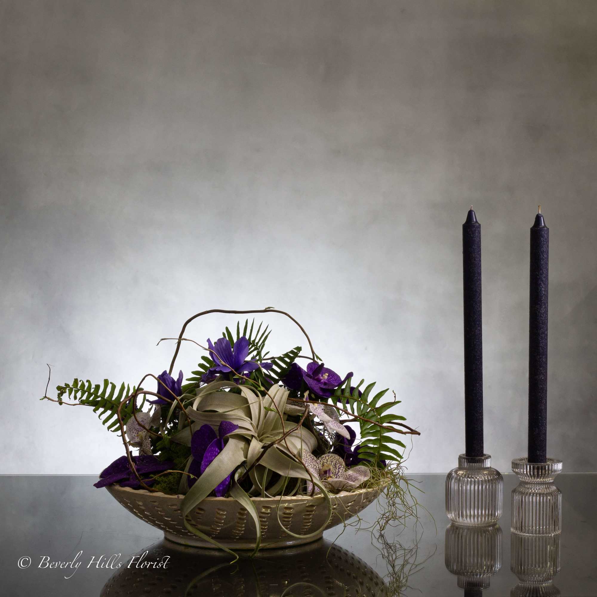This contemporary display featuring unique air plant coupled with vibrant purple vanda