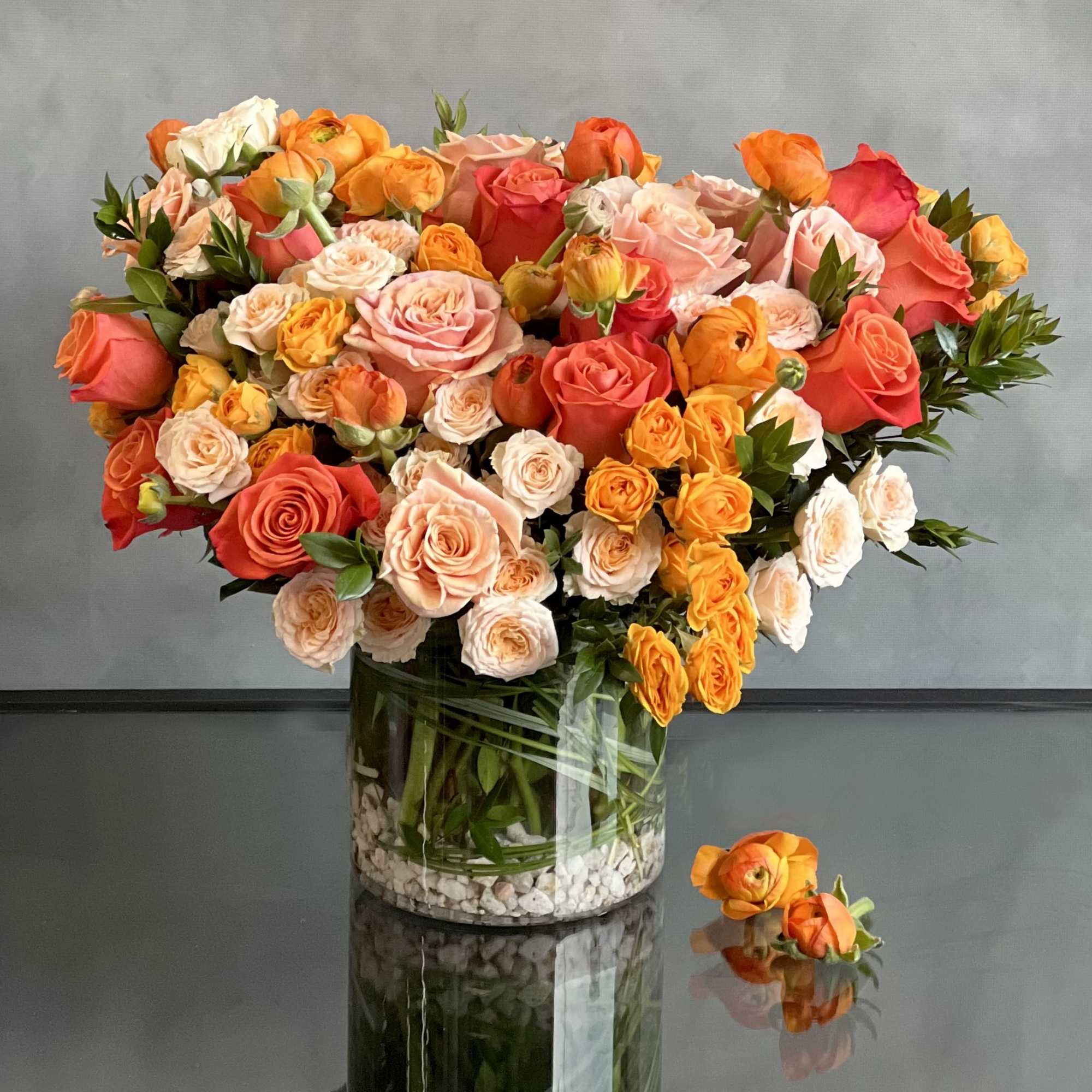 This upscale and uptown floral arrangement showcases a stunning combination of orange