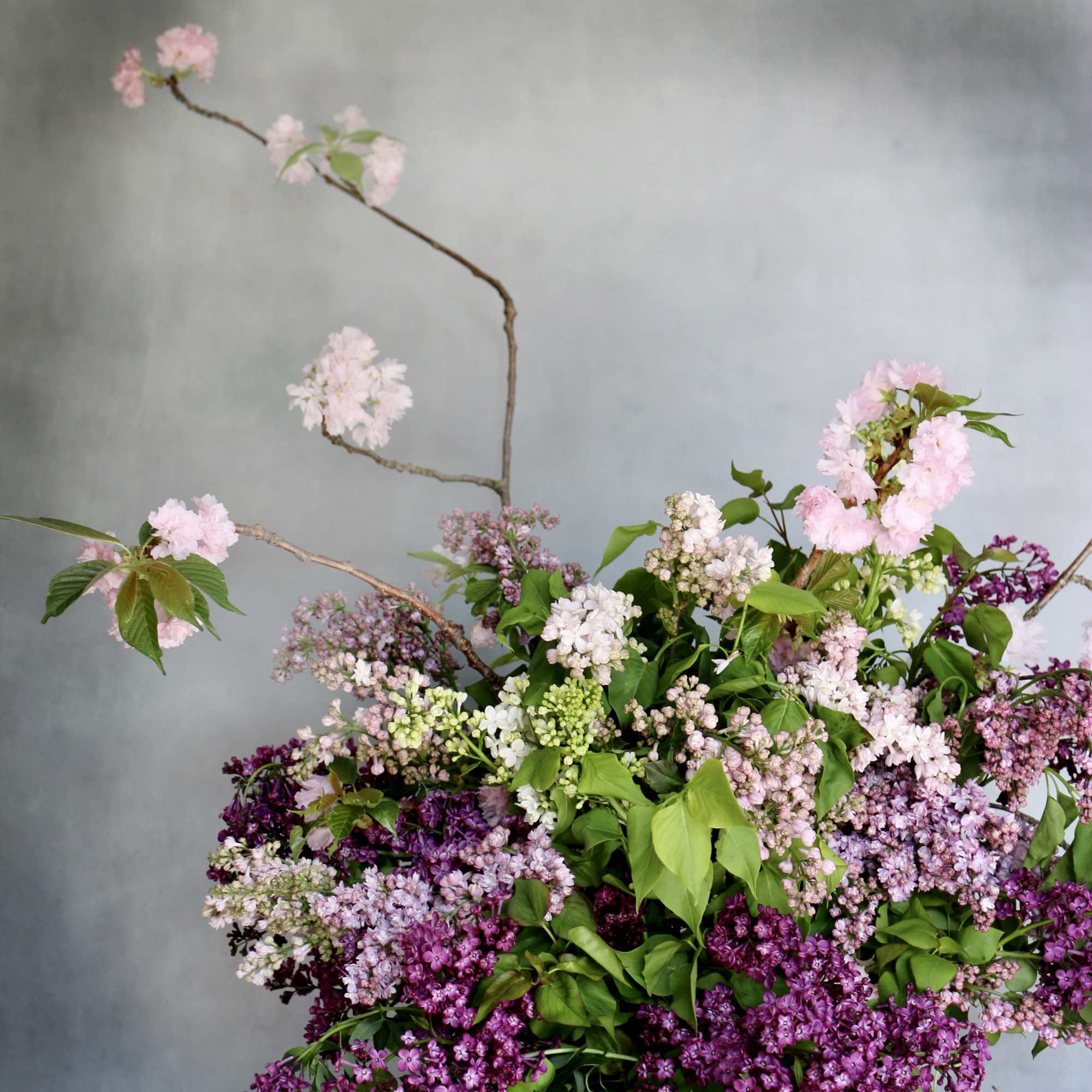 Purple shades of lilac paired with cherry blossom makes this arrangement eye