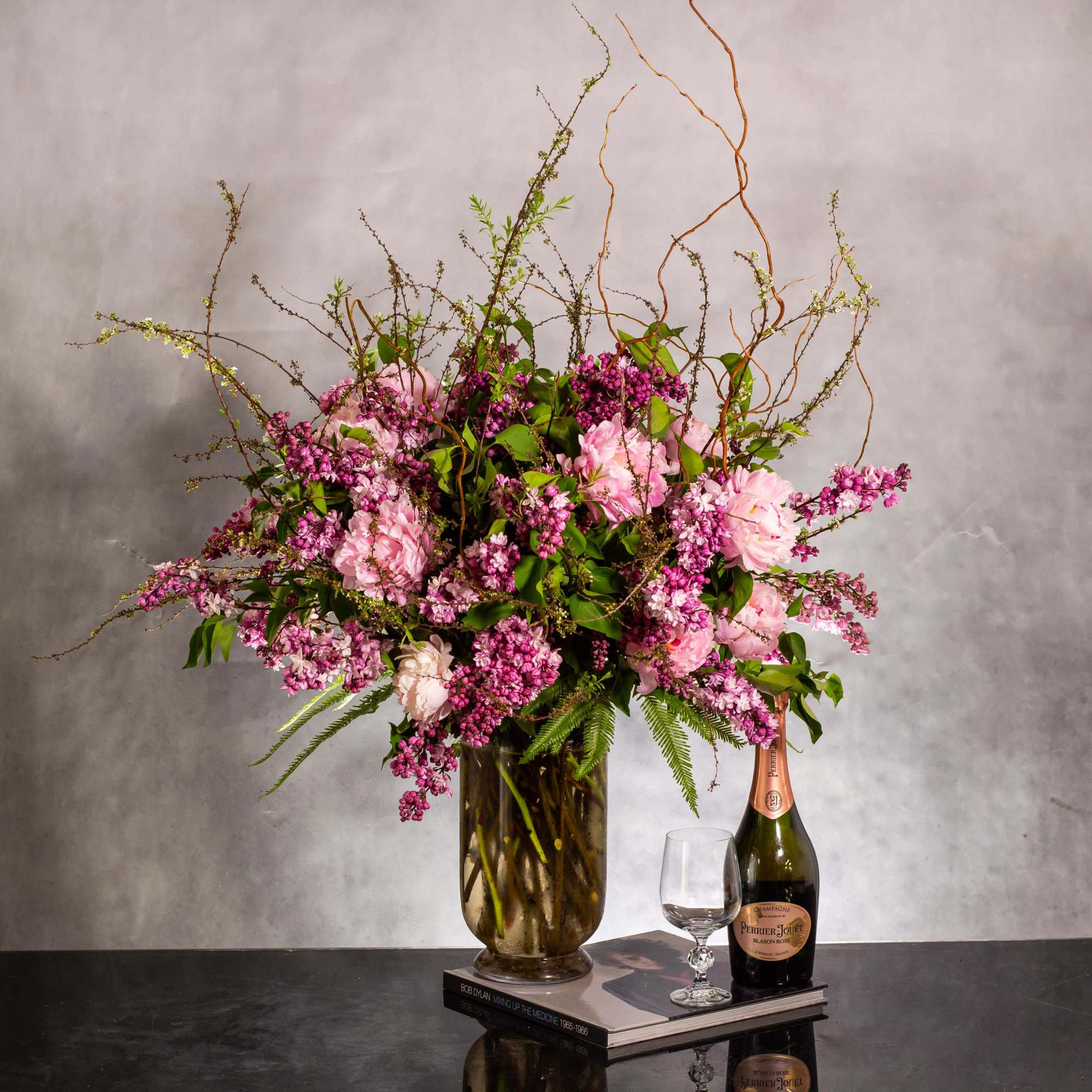 The grand display features an organic arrangement of fragrant lilacs, peonies, and