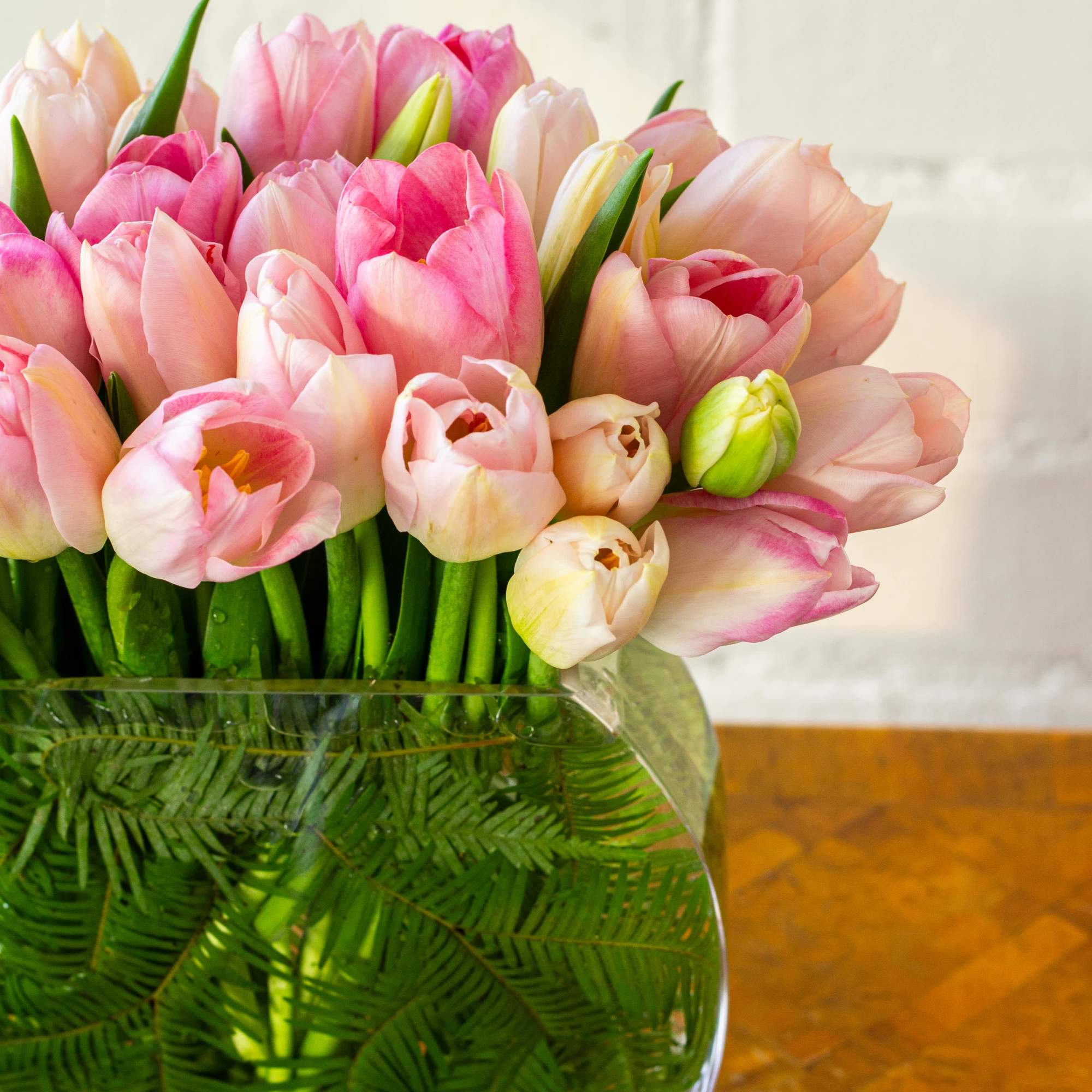 The beautiful arrangement showcases 50 tulips gathered in a modern vase, creating