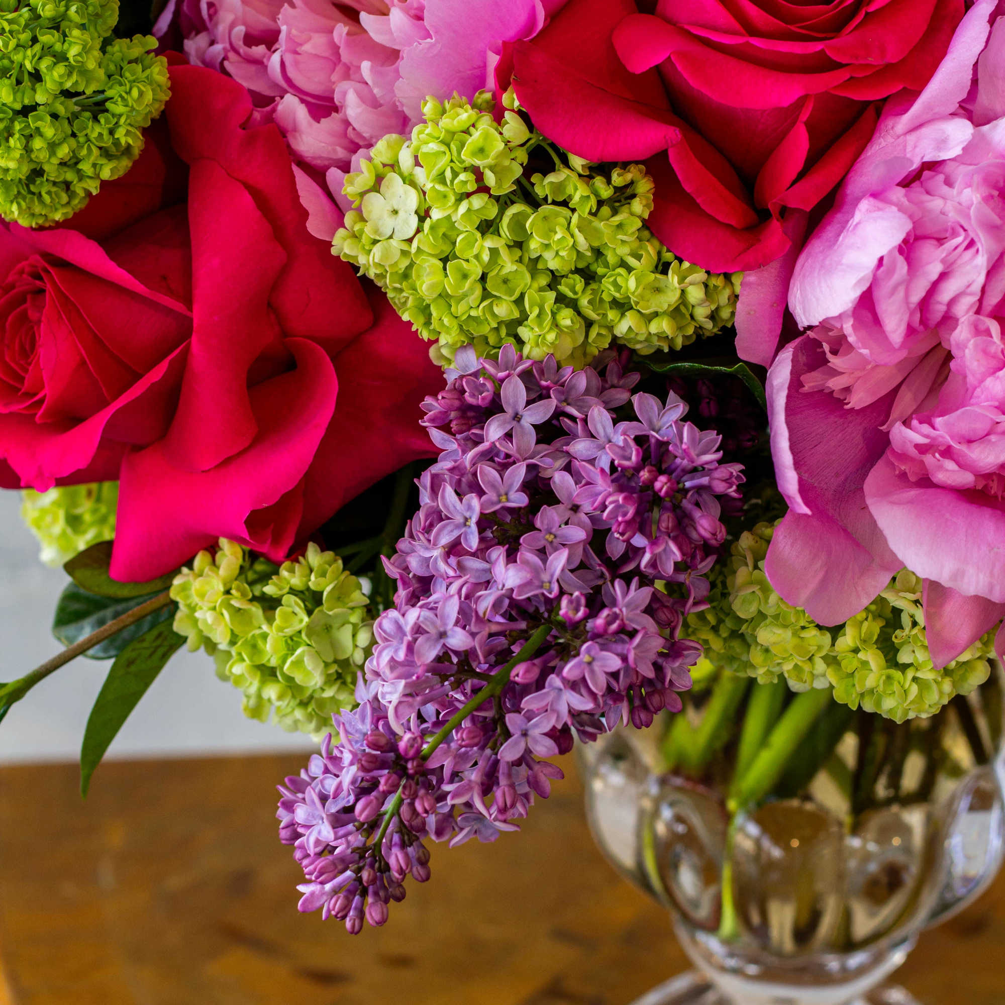The floral arrangement is a sight to behold, showcasing large-headed pink peonies