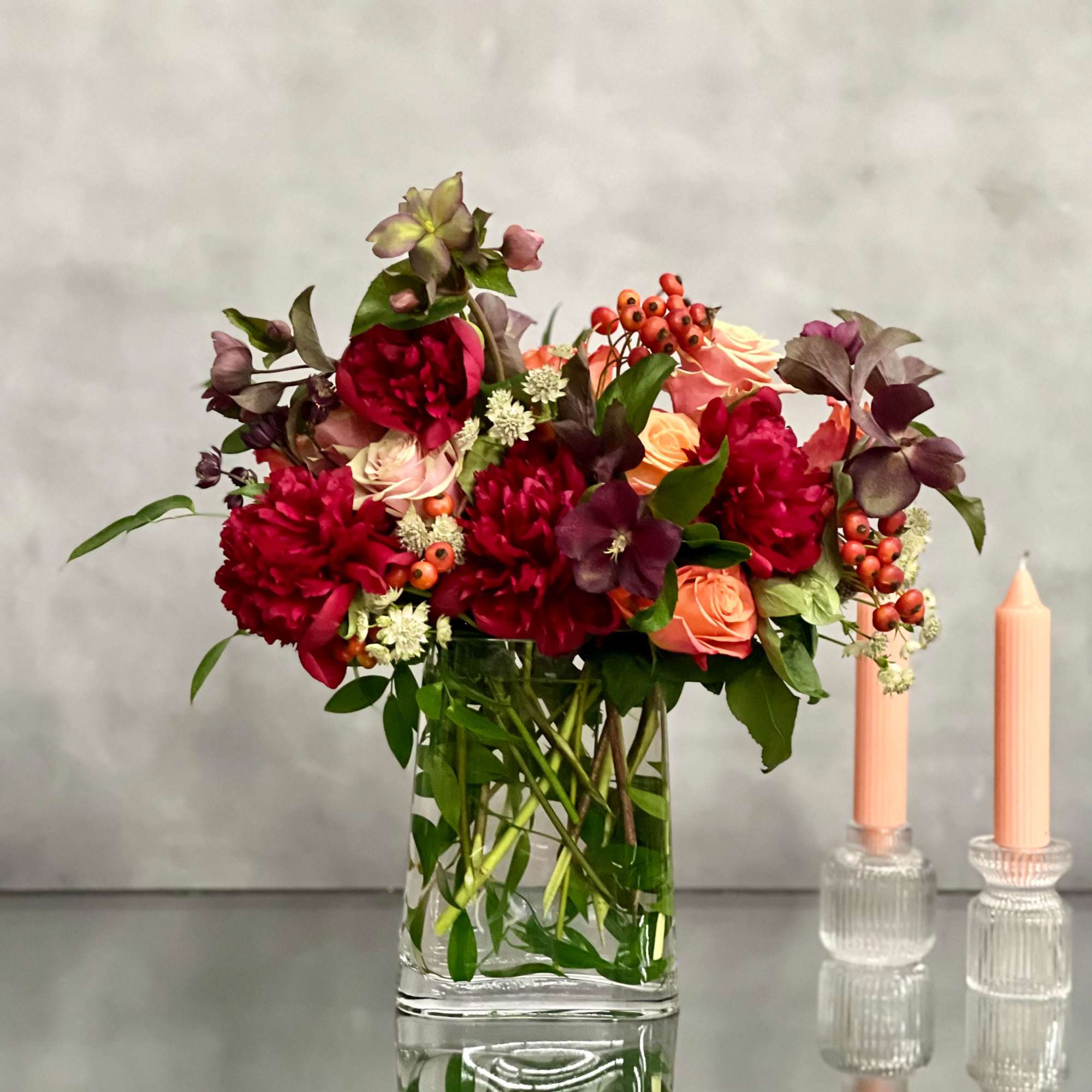 A majestic combination of orange roses, burgundy peonies and a variety of