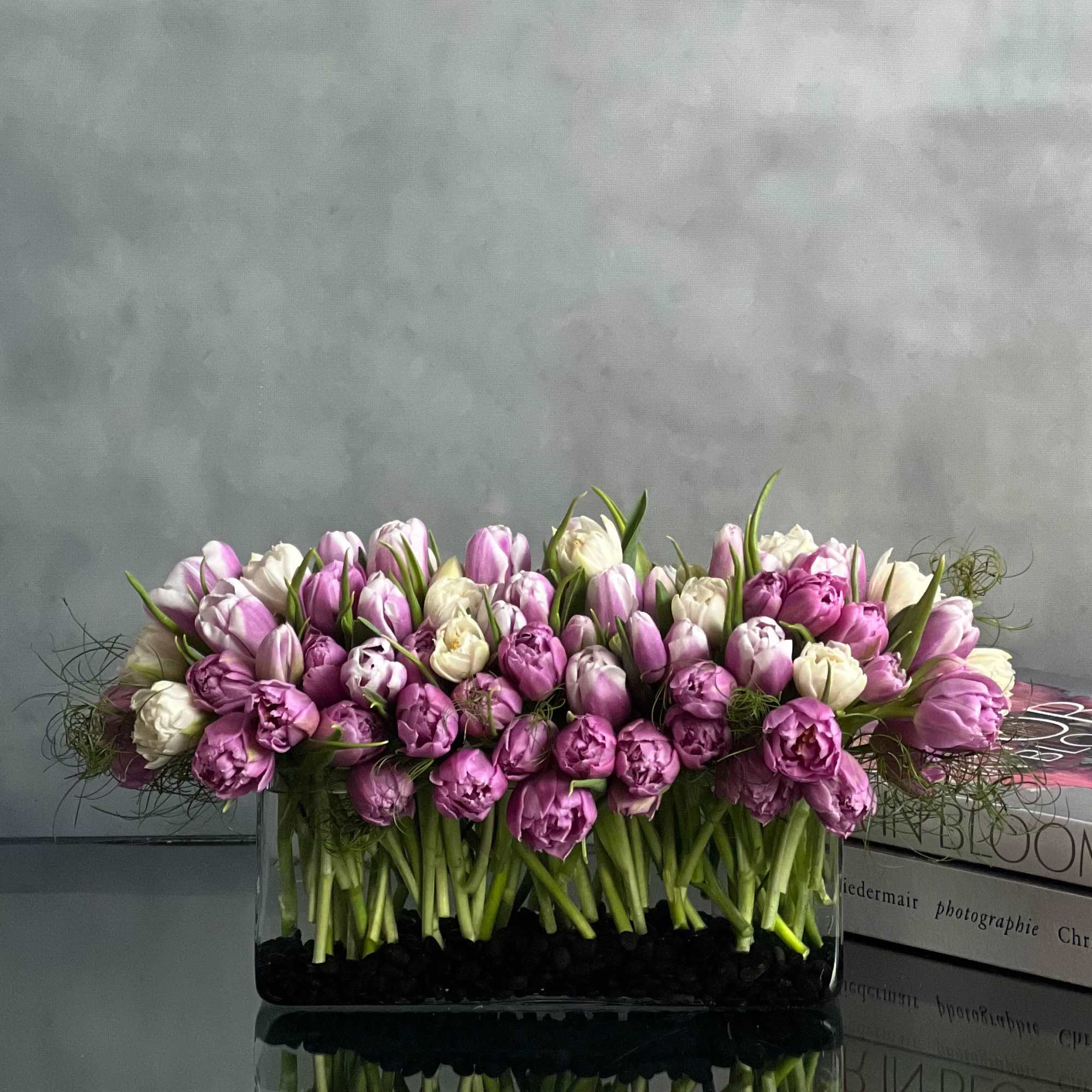 This modern low centerpiece of tulips will surely impressed anyone. Rows of