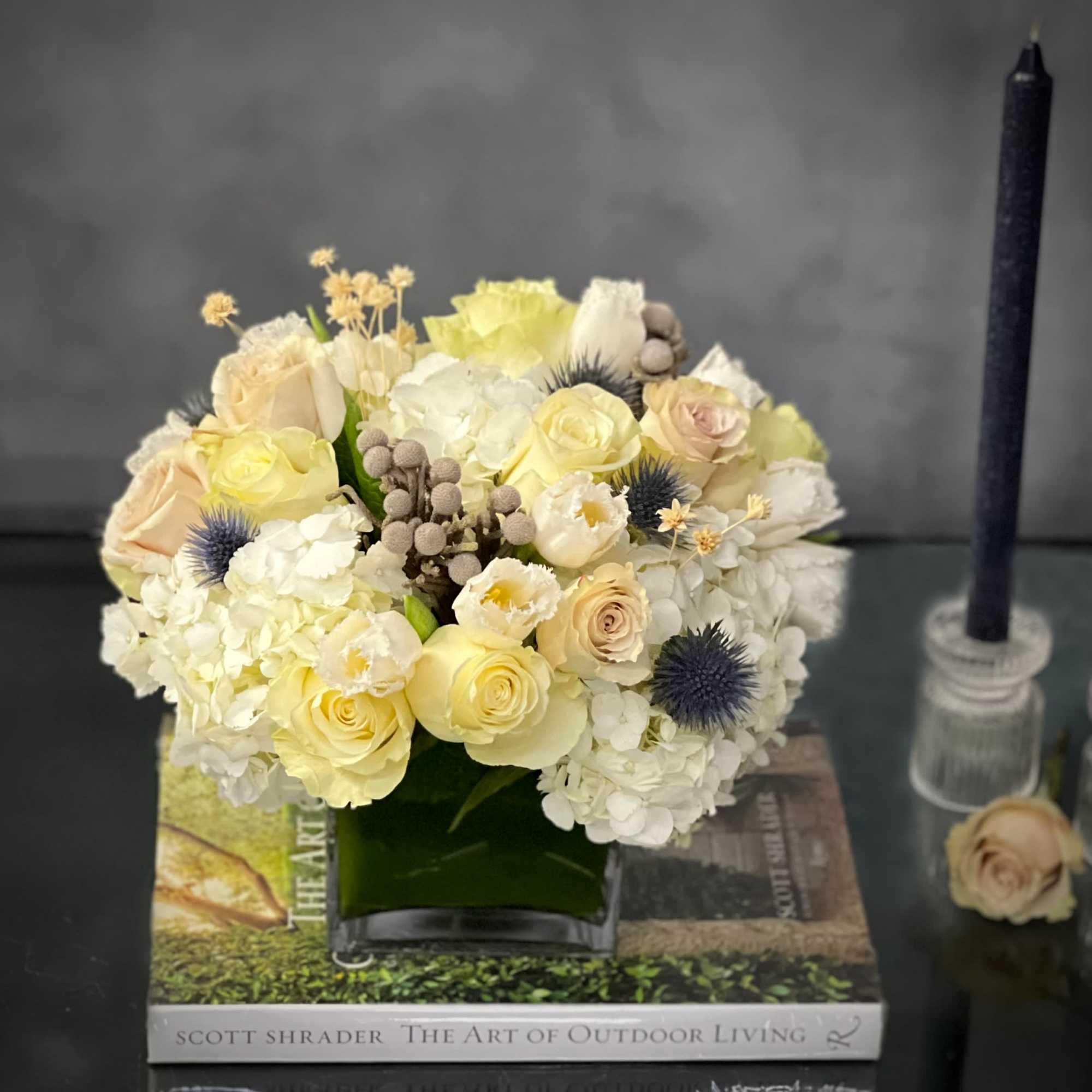 Our beautiful arrangement consists of White Roses, Hydrangeas, Thistles, Cream Roses placed